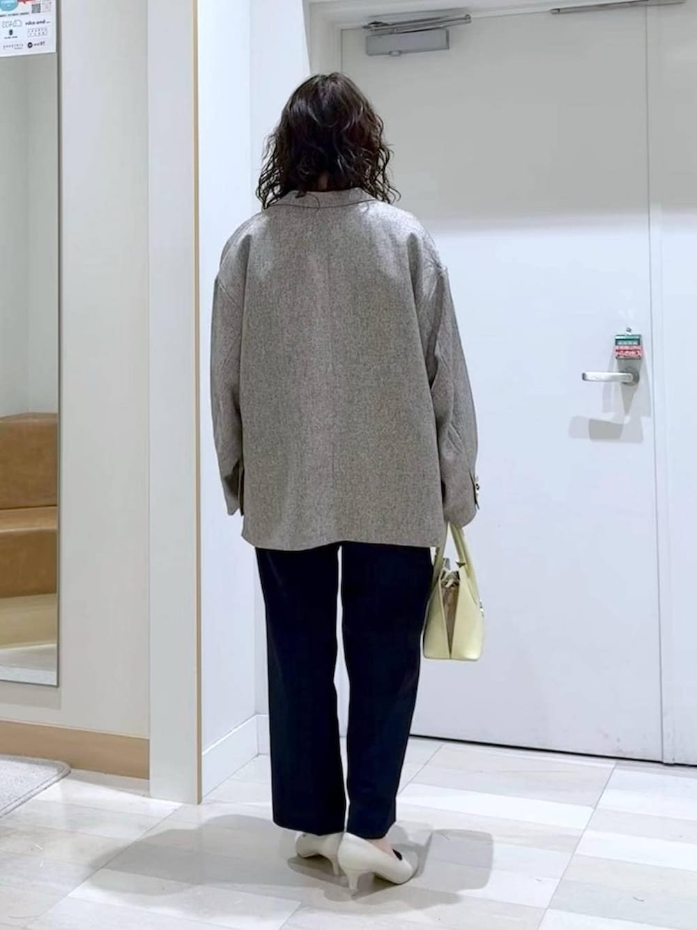 イエロー系のショルダーバッグ、ホワイト系のパンプス、ブルー系のセットアップを着用したレディースの春コーディネートの4枚目の写真