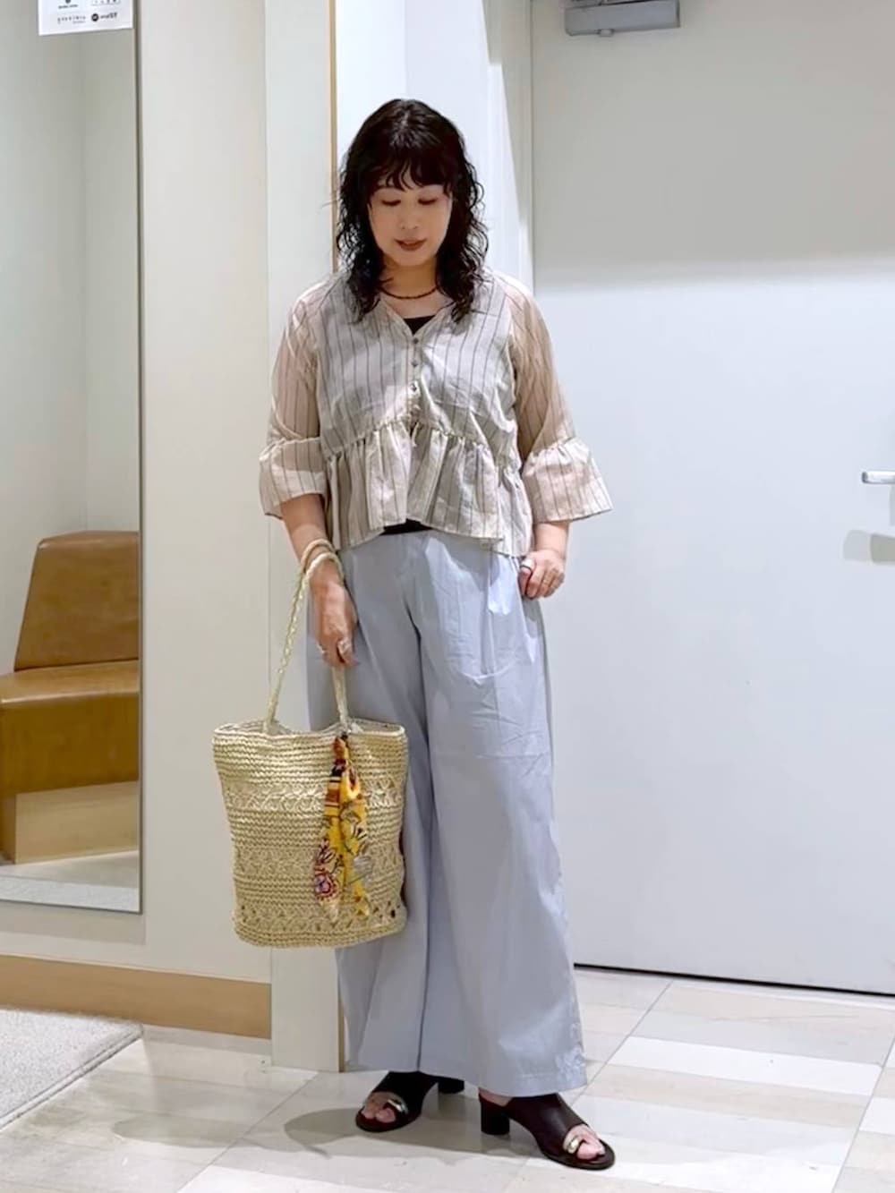 グレー系のその他パンツ、ブラウン系のタンクトップ、ベージュ系のトートバッグを着用したレディースの夏コーディネートの3枚目の写真
