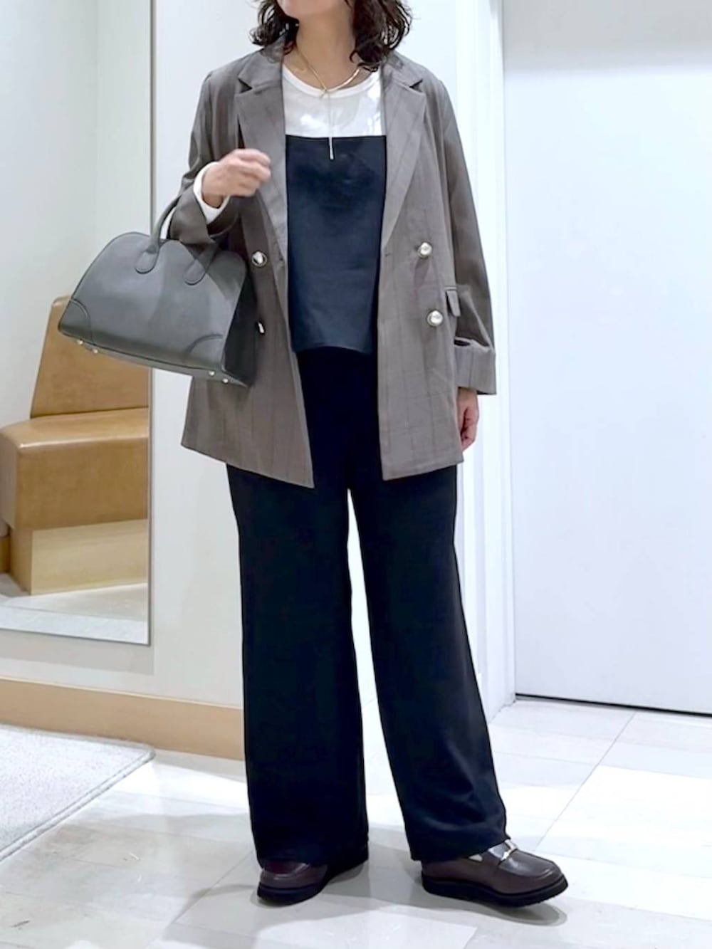 ブラウン系のローファー、グリーン系のショルダーバッグ、ブラック系のサロペット/オーバーオールを着用したレディースの秋コーディネートの5枚目の写真