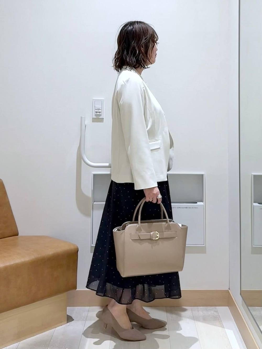 ホワイト系のノーカラージャケット、ホワイト系のシャツ/ブラウス、ベージュ系のパンプスを着用したレディースの春コーディネートの3枚目の写真