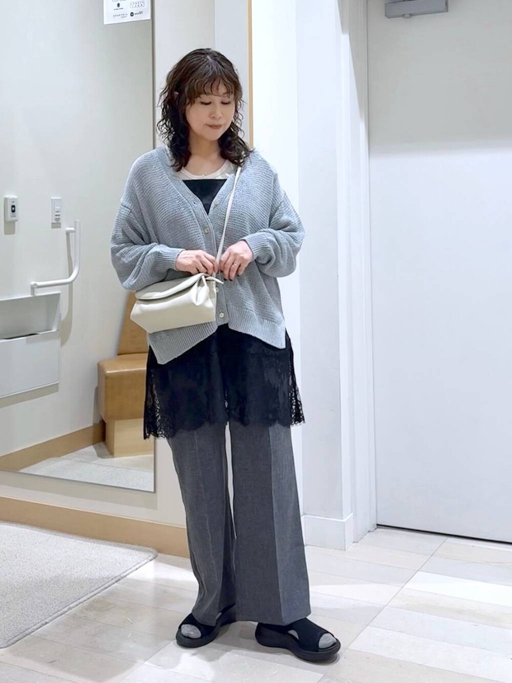 ベージュ系のショルダーバッグ、グレー系のその他パンツ、ブルー系のカーディガン/ボレロを着用したレディースの春コーディネートの2枚目の写真