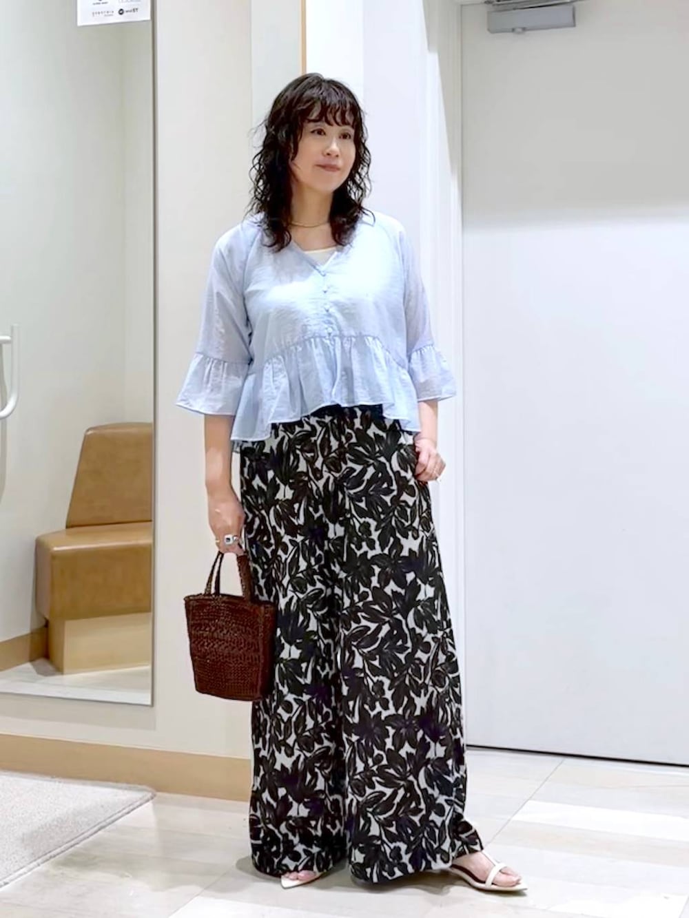 ベージュ系のその他パンツ、ホワイト系のタンクトップ、ブラウン系のクラッチバッグを着用したレディースの夏コーディネートの2枚目の写真