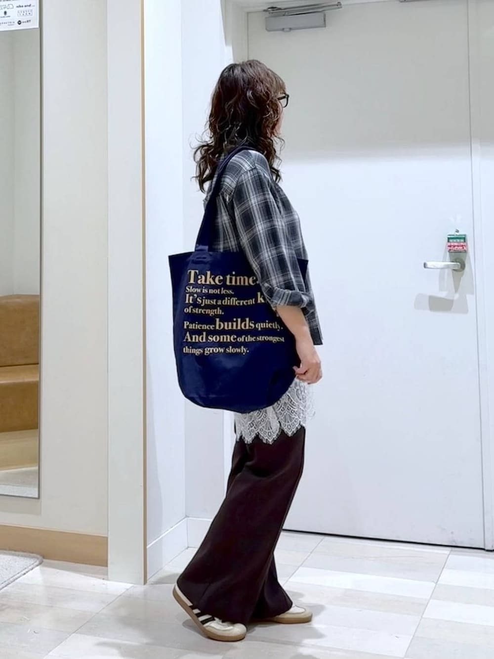 ブルー系のトートバッグ、ブラック系のシャツ/ブラウス、ブラウン系のスウェットパンツを着用したレディースの春コーディネートの3枚目の写真