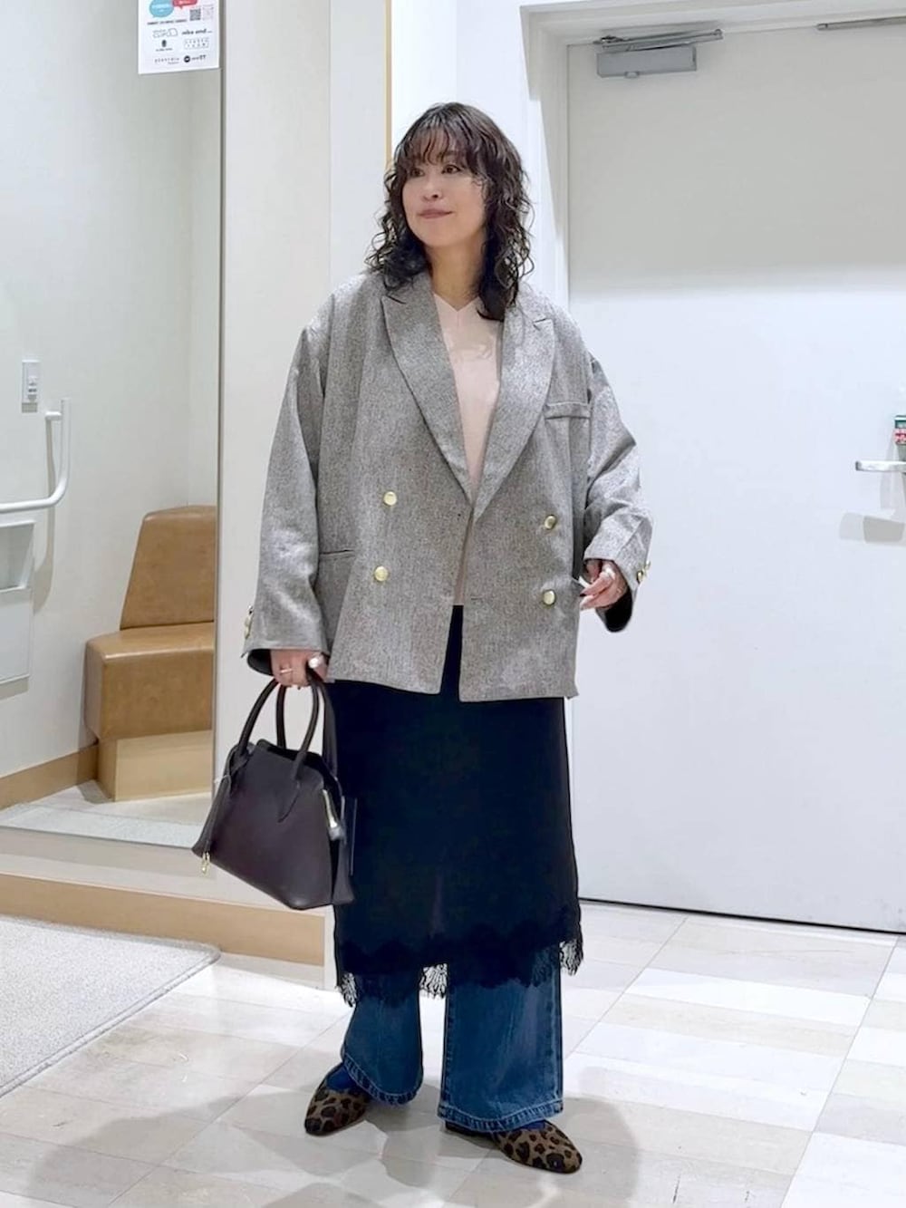 その他のパンプス、ブラウン系のショルダーバッグ、ブルー系のデニムパンツを着用したレディースの春コーディネートの2枚目の写真