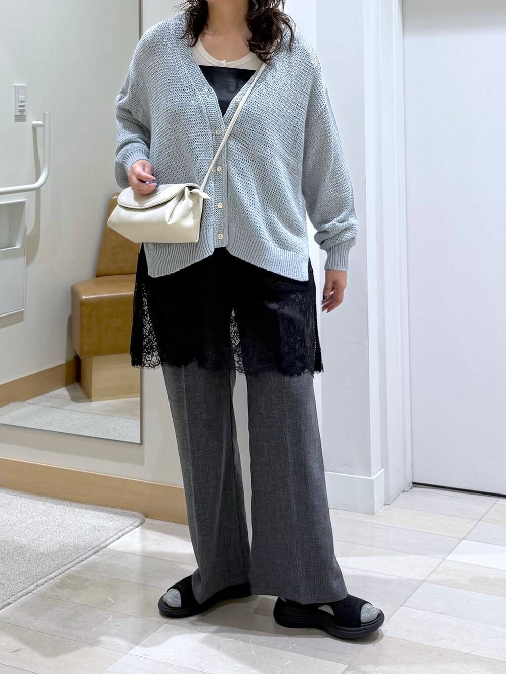 ベージュ系のショルダーバッグ、グレー系のその他パンツ、ブルー系のカーディガン/ボレロを着用したレディースの春コーディネートの5枚目の写真