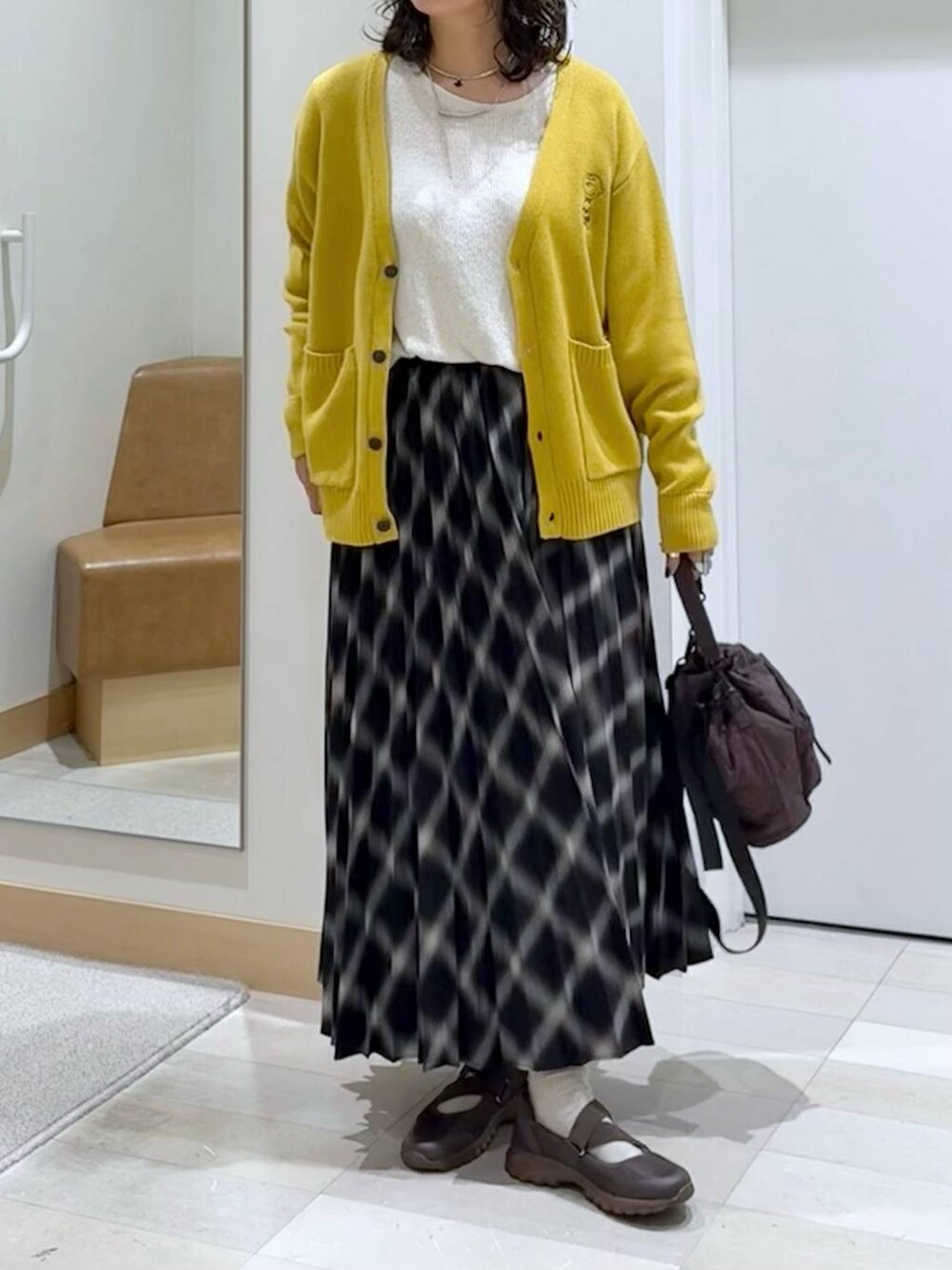 ブラウン系のスニーカー、ベージュ系のニット/セーター、ブラウン系のショルダーバッグを着用したレディースの秋コーディネートの5枚目の写真