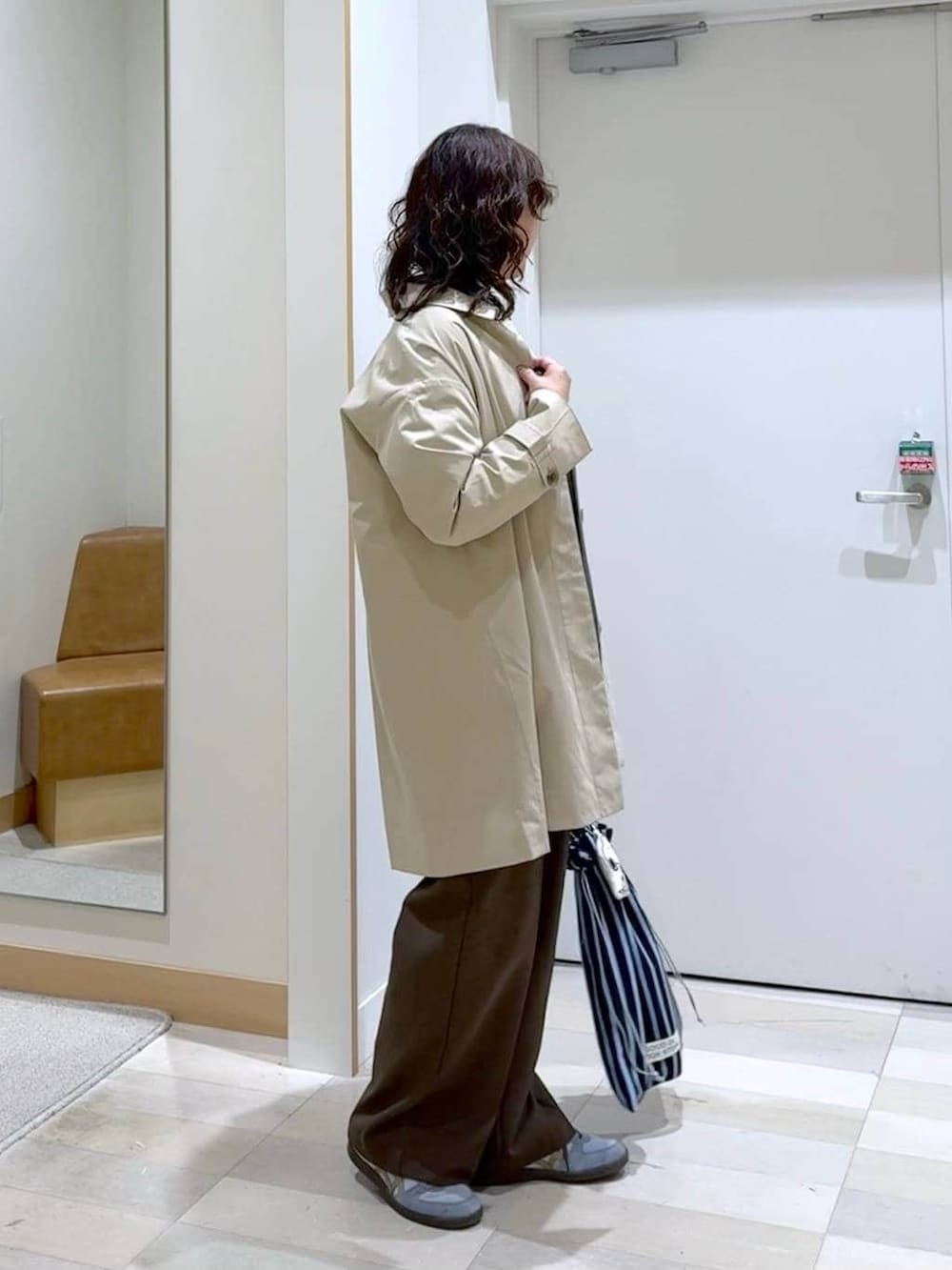 ブルー系のシャツ/ブラウス、ブラウン系のその他パンツ、グレー系のニット/セーターを着用したレディースの春コーディネートの3枚目の写真