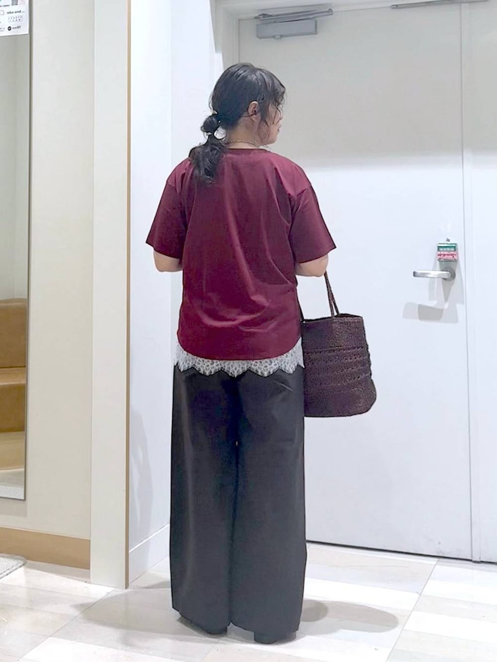 ブラウン系のその他パンツ、レッド系のTシャツ/カットソー、ブラウン系のクラッチバッグを着用したレディースの夏コーディネートの4枚目の写真