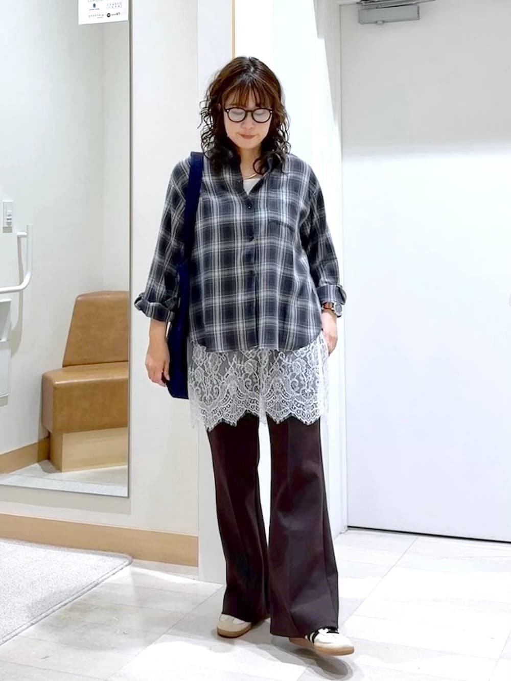 ブルー系のトートバッグ、ブラック系のシャツ/ブラウス、ブラウン系のスウェットパンツを着用したレディースの春コーディネートの2枚目の写真