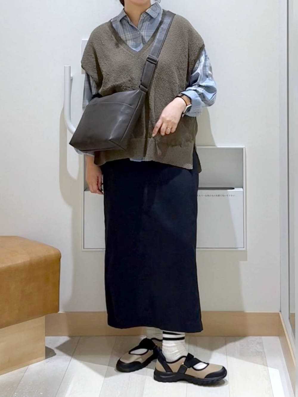 ベージュ系のスニーカー、ブラック系のスカート、ブラウン系のベストを着用したレディースの夏コーディネートの5枚目の写真