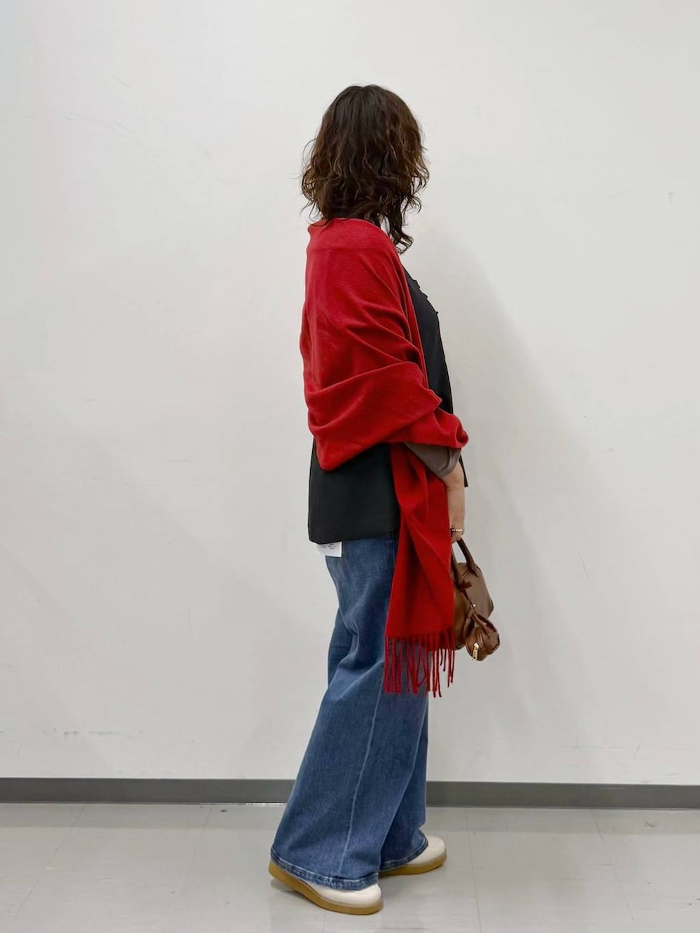 ホワイト系のローファー、ブルー系のデニムパンツ、ブラウン系のハンドバッグを着用したレディースの春コーディネートの3枚目の写真