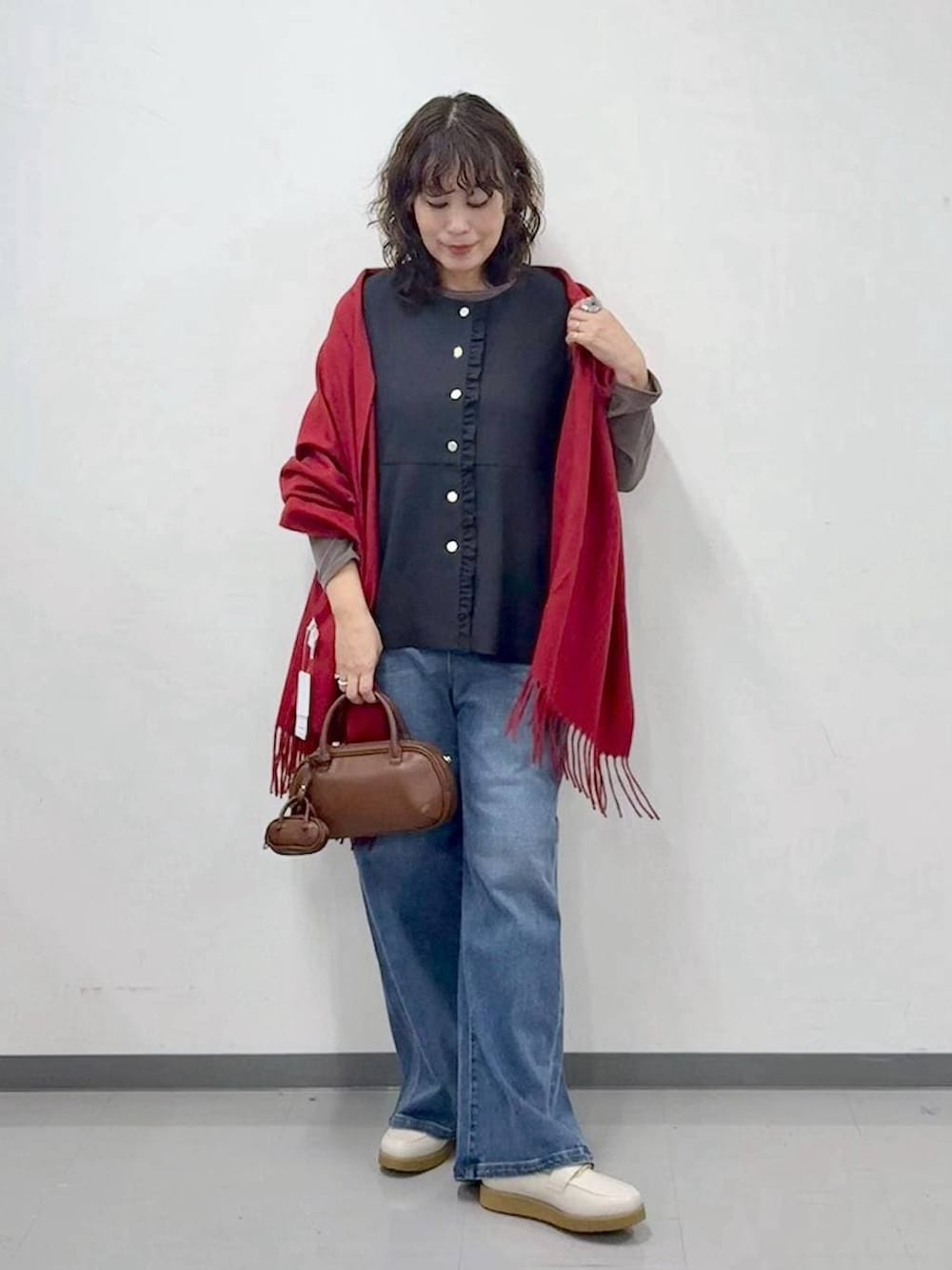 ホワイト系のローファー、ブルー系のデニムパンツ、ブラウン系のハンドバッグを着用したレディースの春コーディネートの2枚目の写真