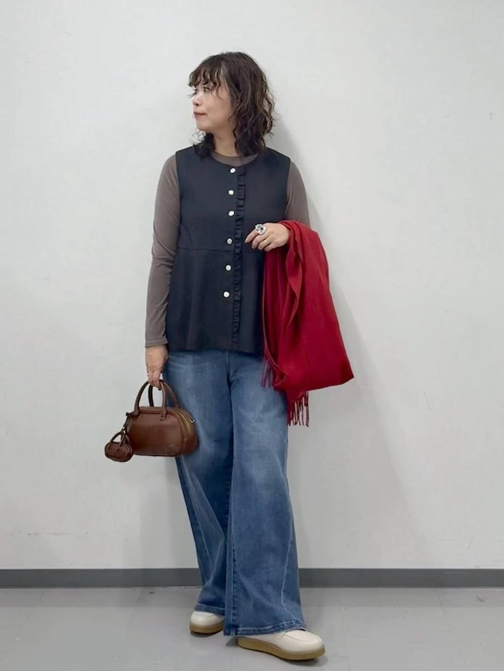 ホワイト系のローファー、ブルー系のデニムパンツ、ブラウン系のハンドバッグを着用したレディースの春コーディネートの5枚目の写真