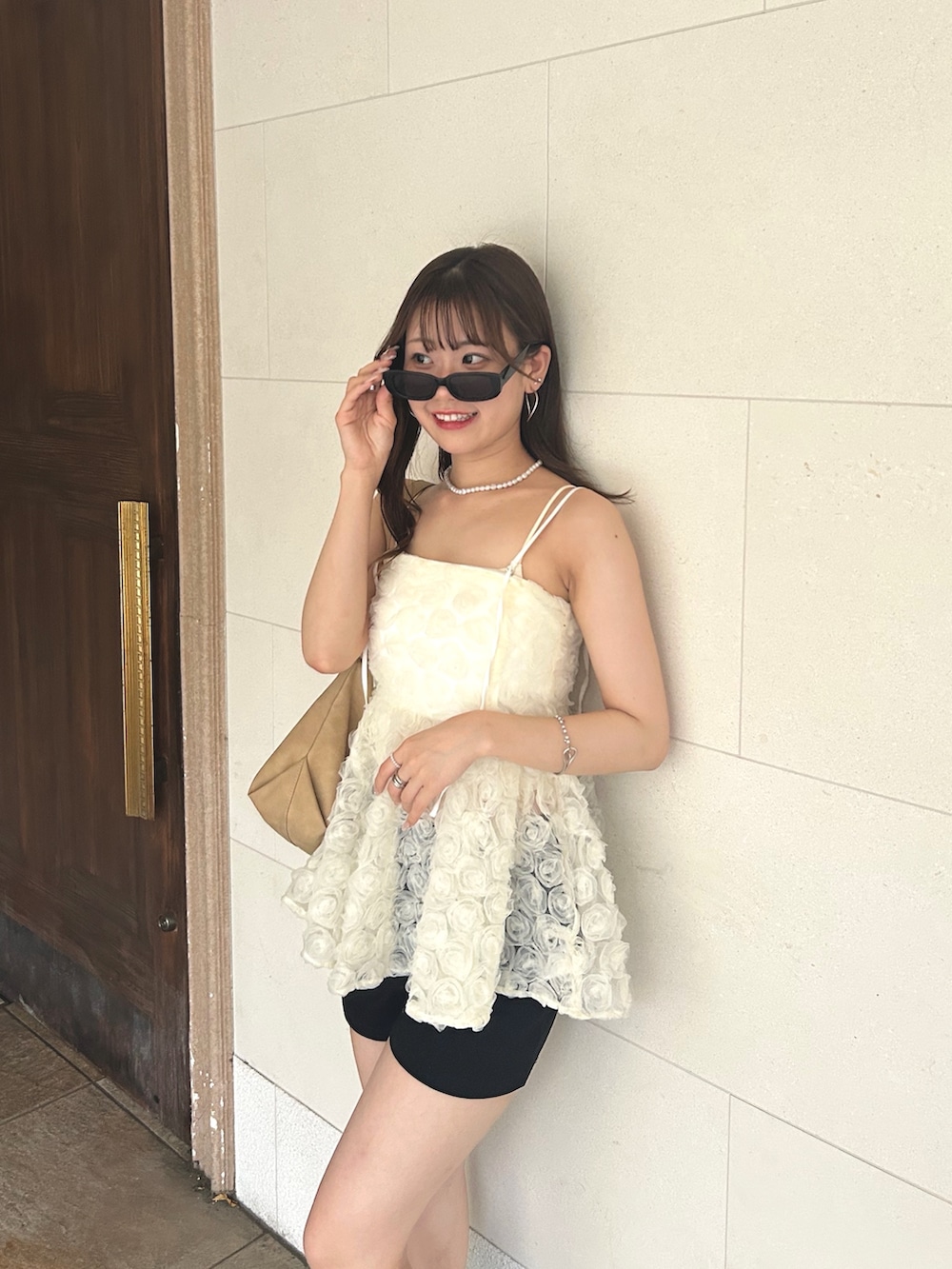 ホワイト系のキャミソール、ベージュ系のショルダーバッグ、ホワイト系のシャツ/ブラウスを着用したレディースの夏コーディネートの4枚目の写真