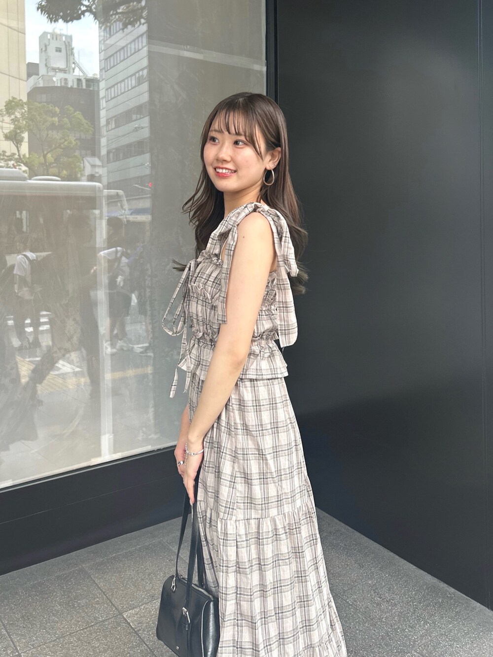 ベージュ系のワンピース、ブラック系のボストンバッグ、ブラック系のサンダルを着用したレディースの夏コーディネートの4枚目の写真