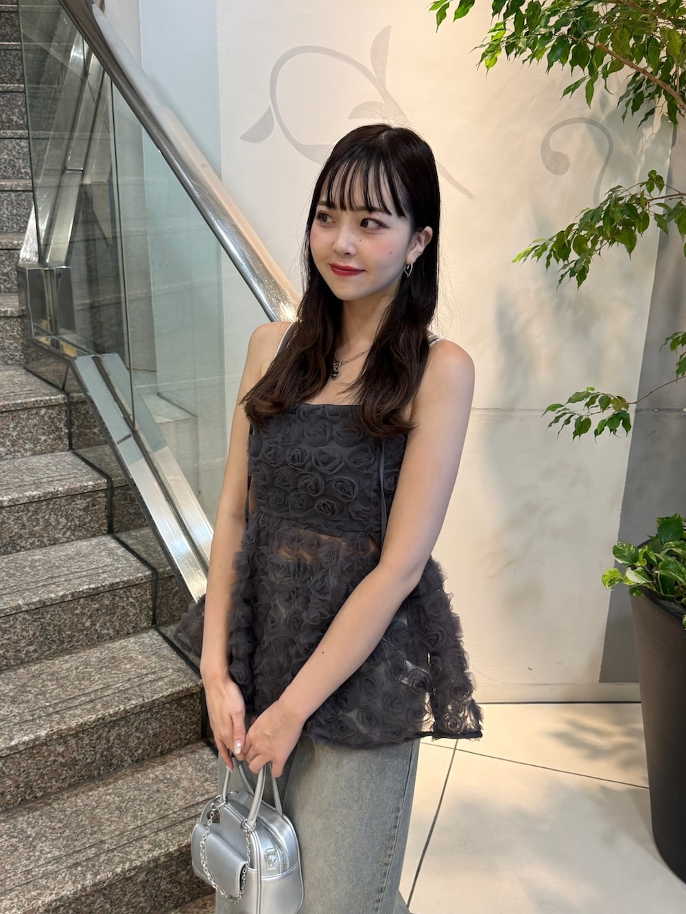 グレー系のシャツ/ブラウス、ブルー系のデニムパンツ、シルバー系のボストンバッグを着用したレディースの夏コーディネートの3枚目の写真