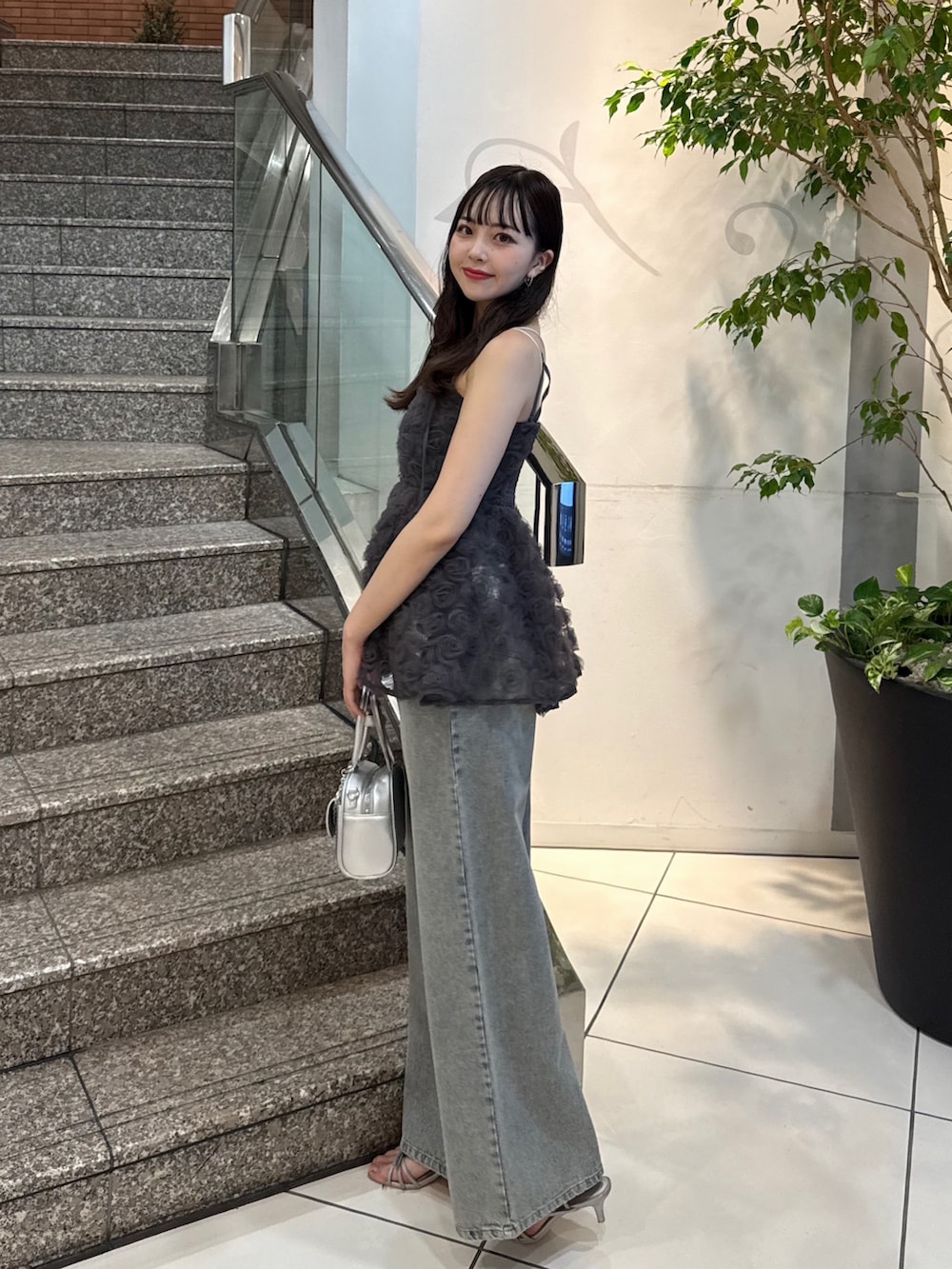 グレー系のシャツ/ブラウス、ブルー系のデニムパンツ、シルバー系のボストンバッグを着用したレディースの夏コーディネートの2枚目の写真