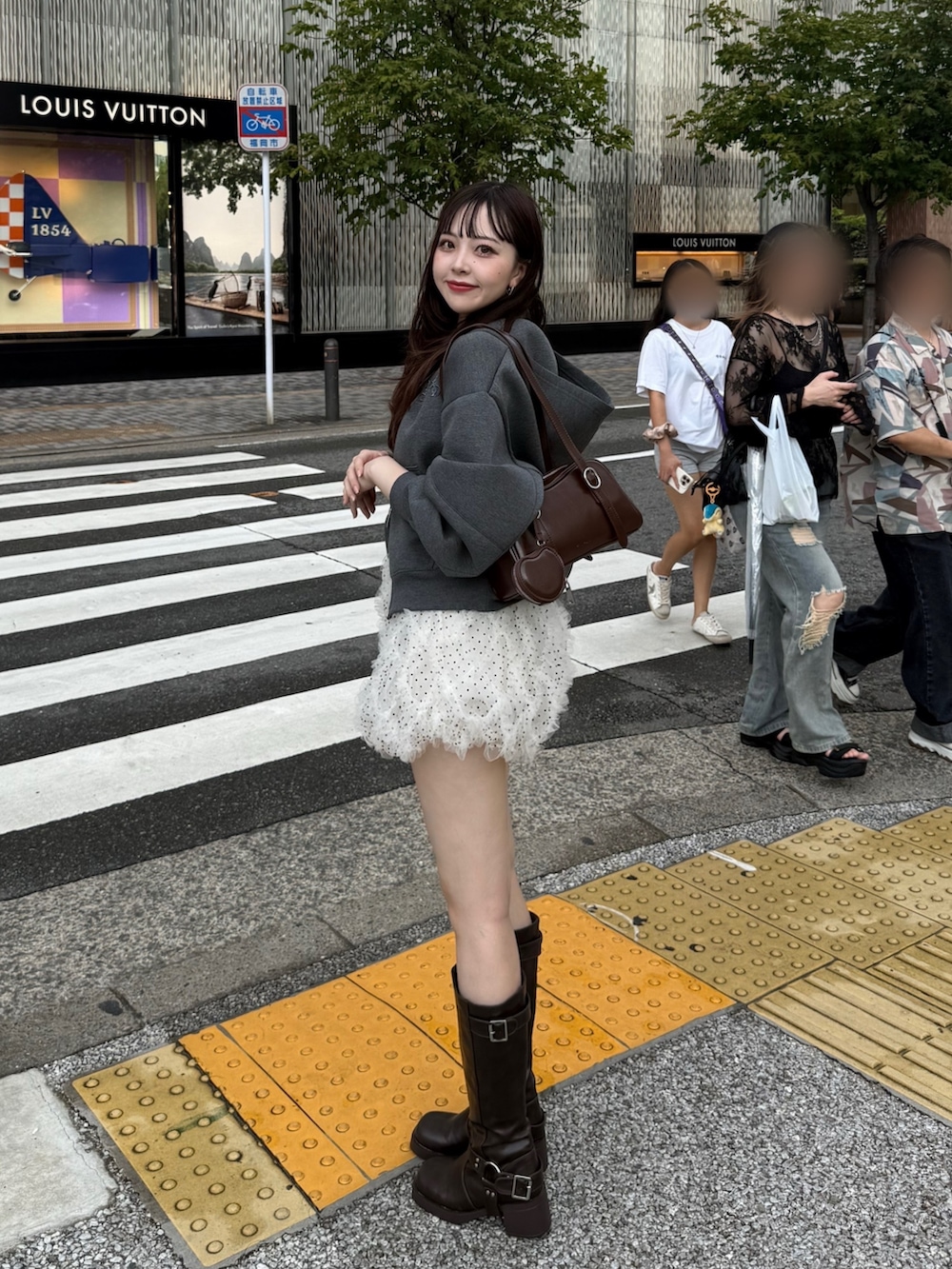 グレー系のパーカー、ホワイト系のその他パンツ、ブラウン系のブーツを着用したレディースの秋コーディネートの3枚目の写真