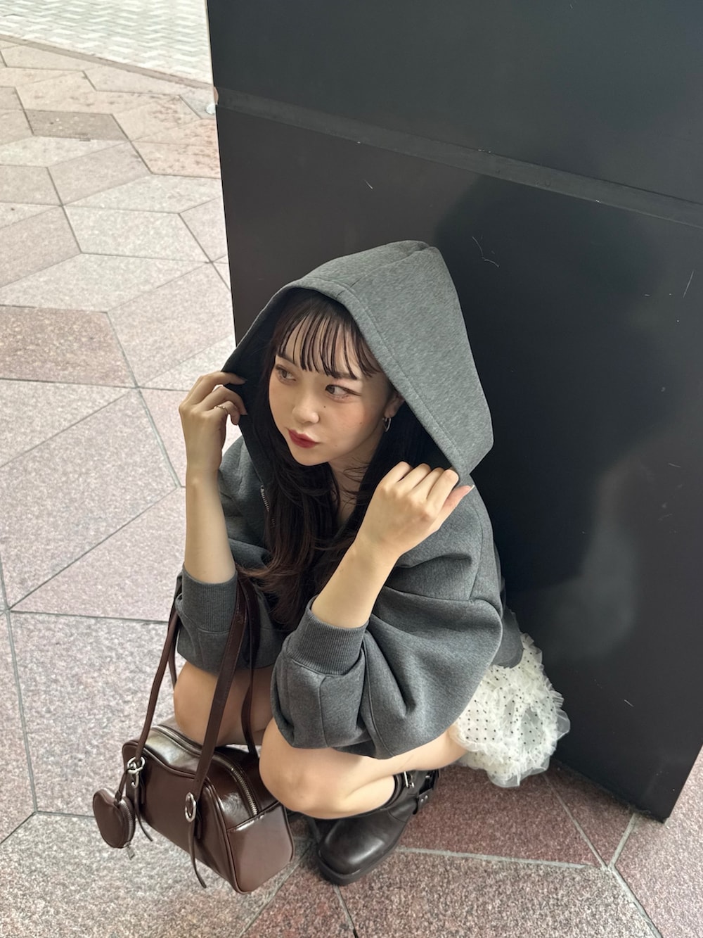 グレー系のパーカー、ホワイト系のその他パンツ、ブラウン系のブーツを着用したレディースの秋コーディネートの5枚目の写真