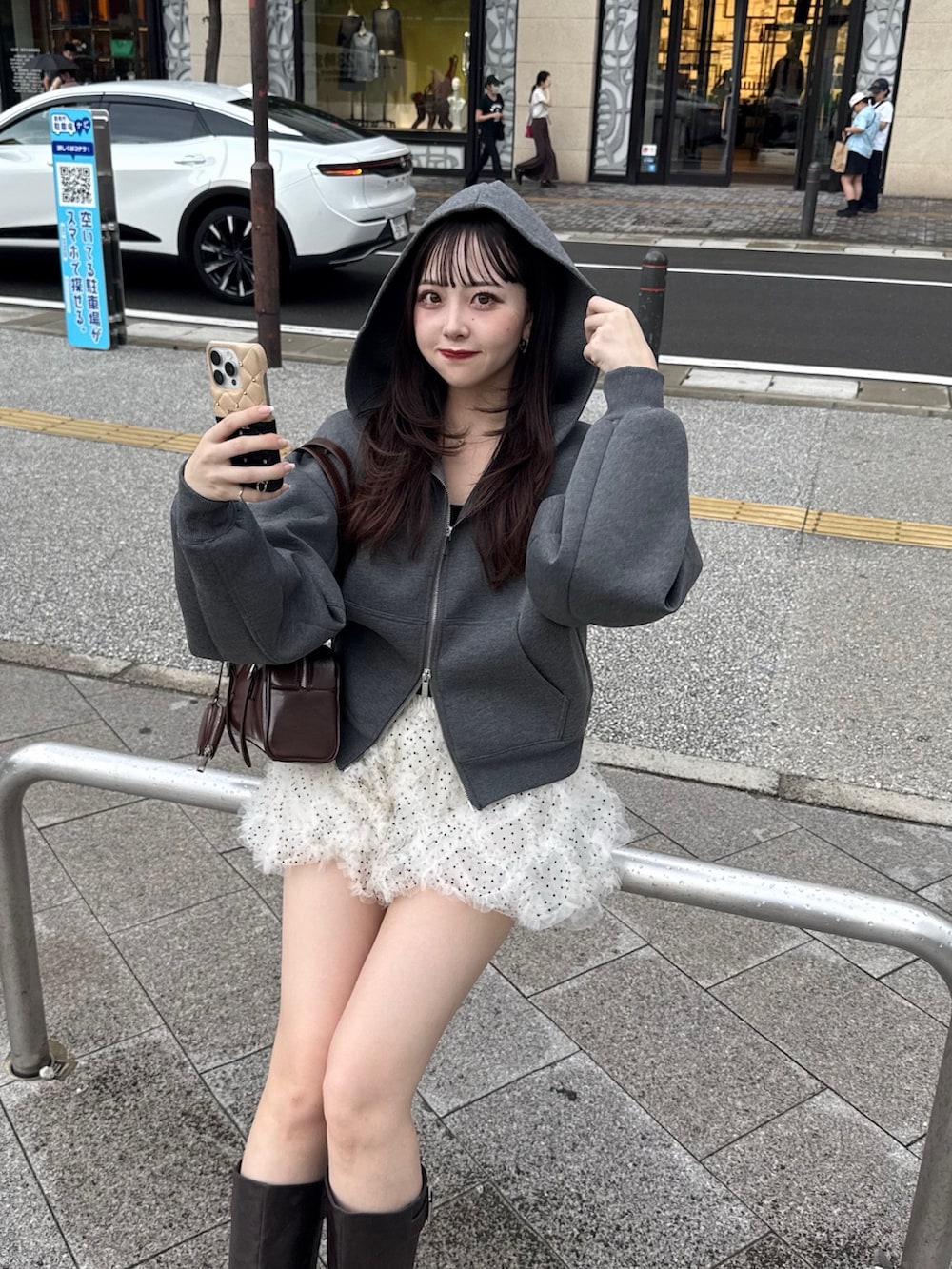 グレー系のパーカー、ホワイト系のその他パンツ、ブラウン系のブーツを着用したレディースの秋コーディネートの2枚目の写真