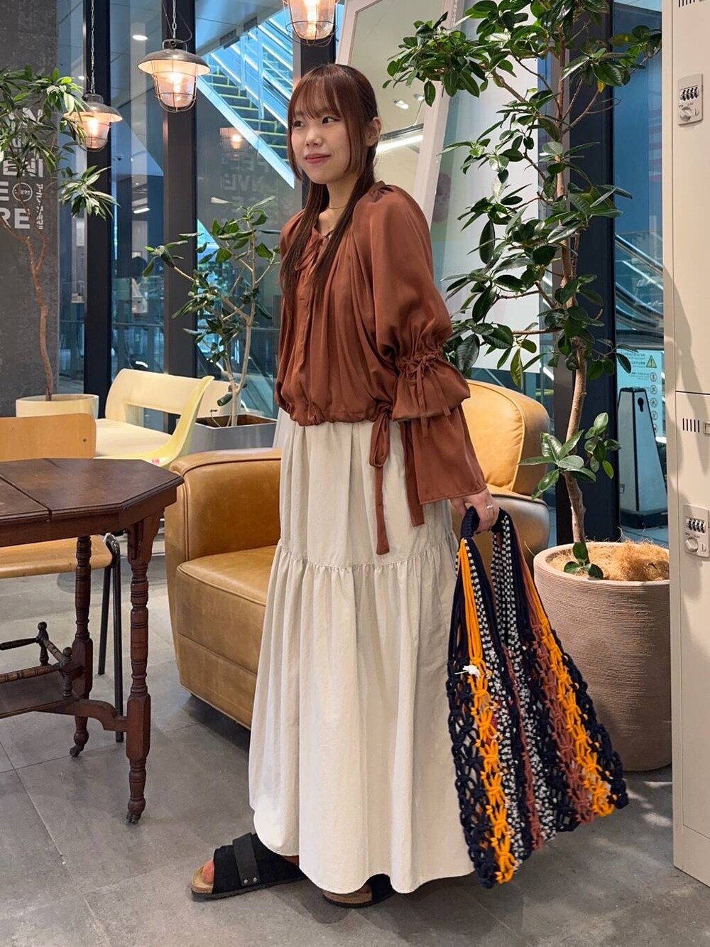 ベージュ系のワンピース、ブラック系のサンダルを着用したレディースの春コーディネートの2枚目の写真