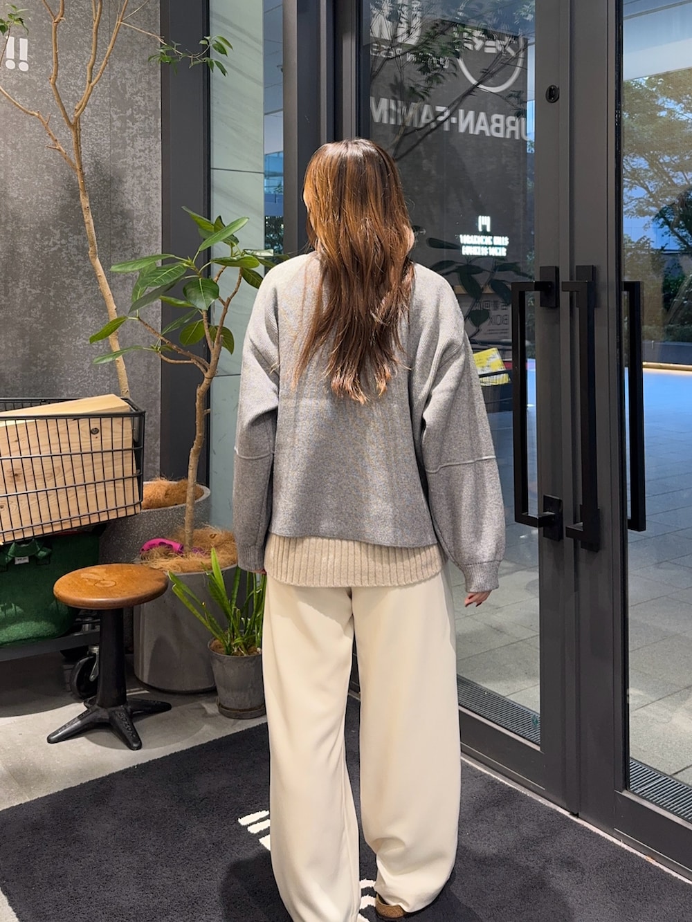 グレー系のブルゾン、ベージュ系のニット/セーター、ホワイト系のその他パンツを着用したレディースの秋コーディネートの3枚目の写真