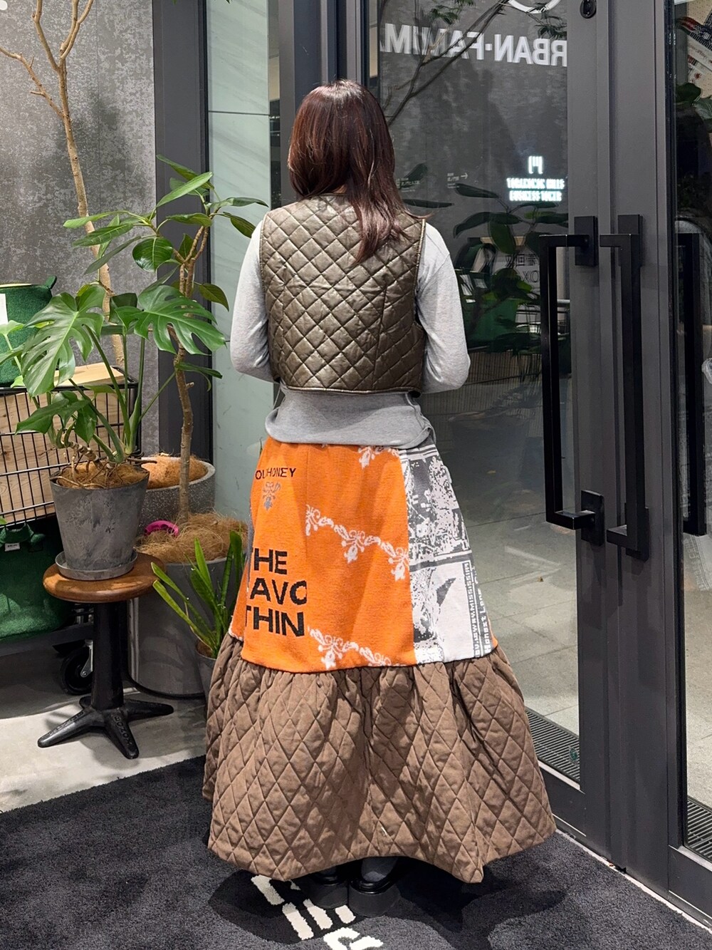 グレー系のカーディガン/ボレロ、オレンジ系のスカートを着用したレディースの冬コーディネートの3枚目の写真