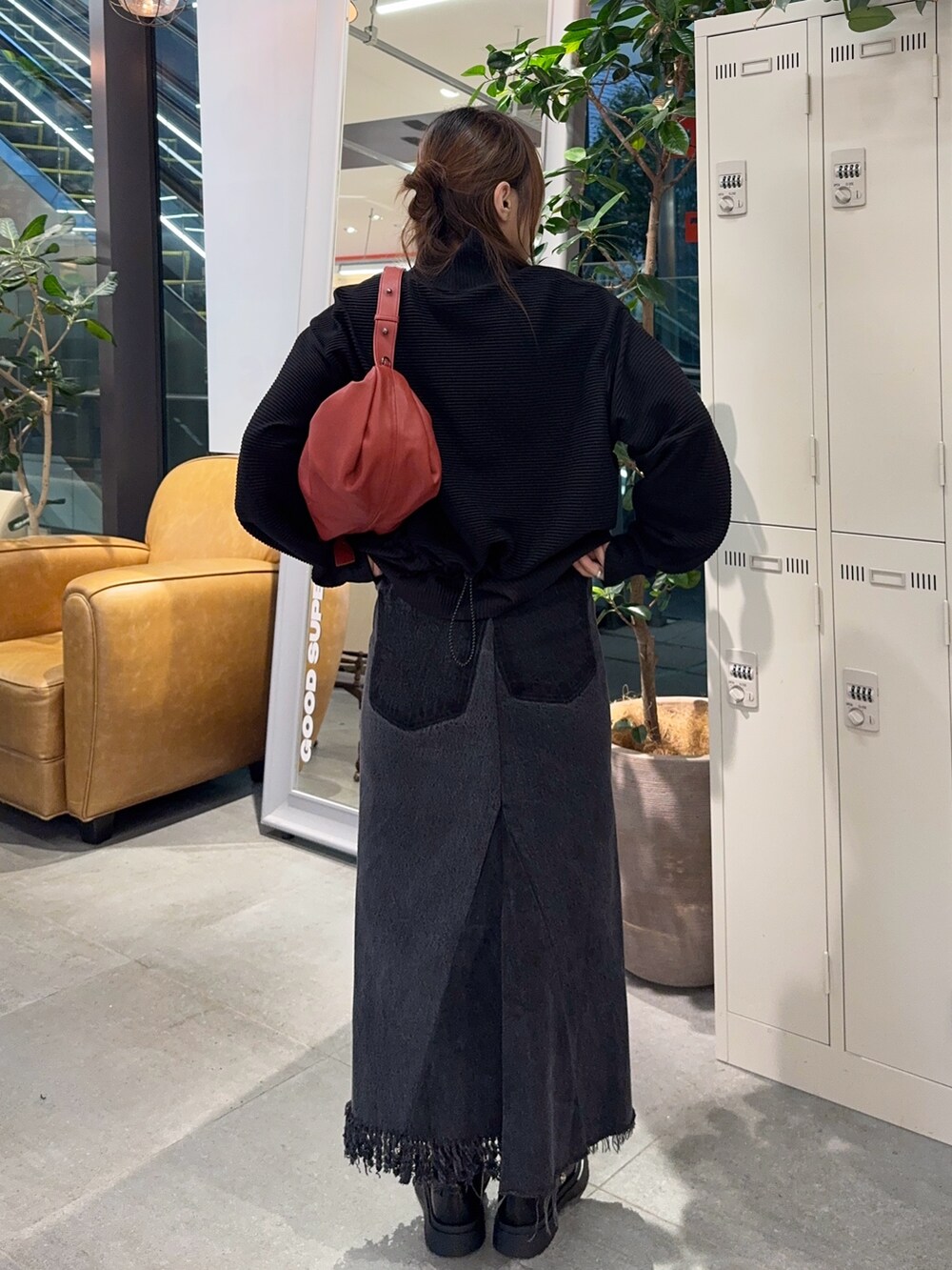 ブラック系のTシャツ/カットソー、ブラック系のデニムスカート、レッド系のショルダーバッグを着用したレディースの秋コーディネートの3枚目の写真