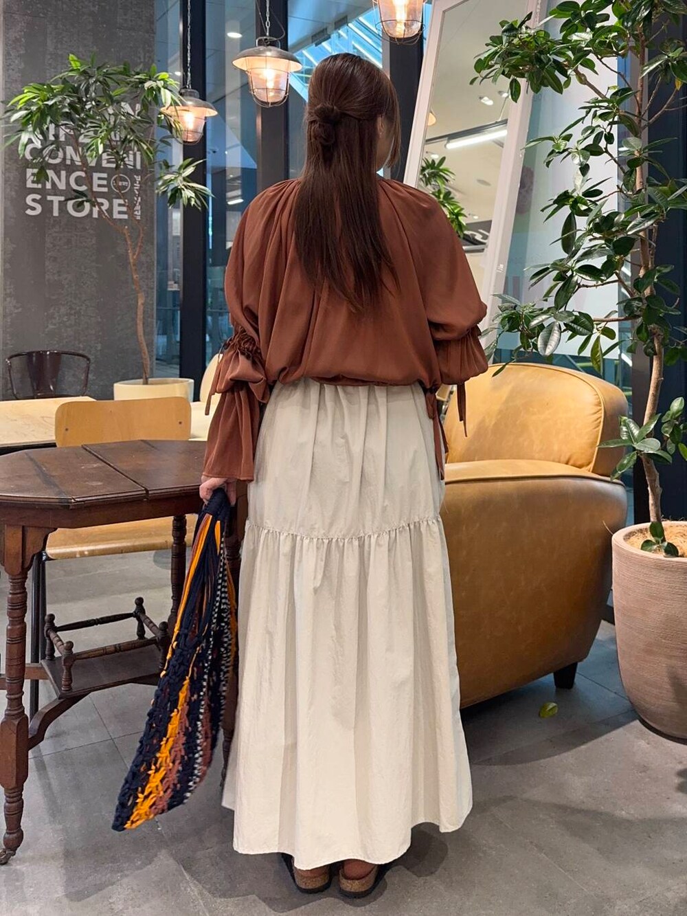 ベージュ系のワンピース、ブラック系のサンダルを着用したレディースの春コーディネートの3枚目の写真