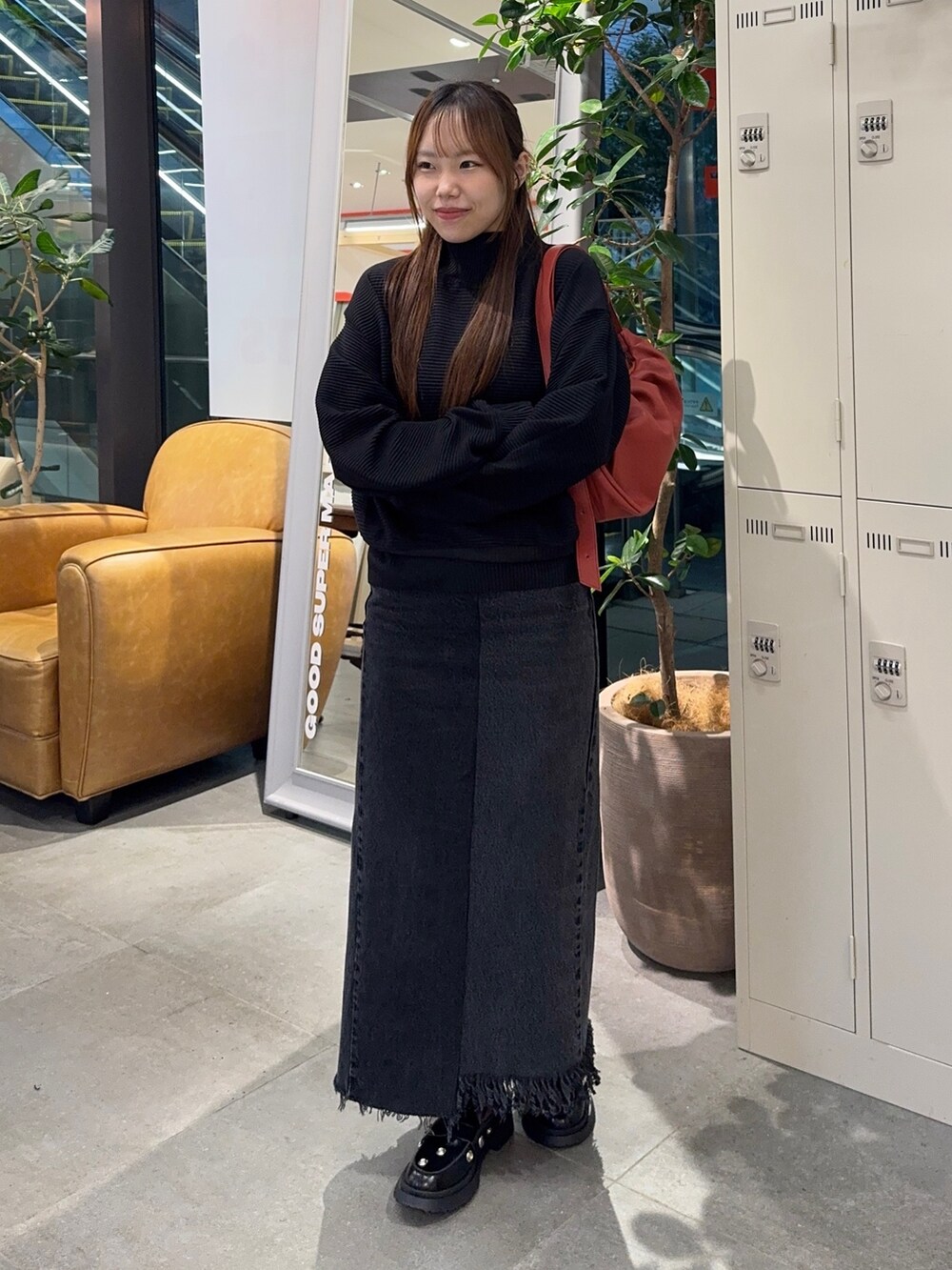 ブラック系のTシャツ/カットソー、ブラック系のデニムスカート、レッド系のショルダーバッグを着用したレディースの秋コーディネートの2枚目の写真