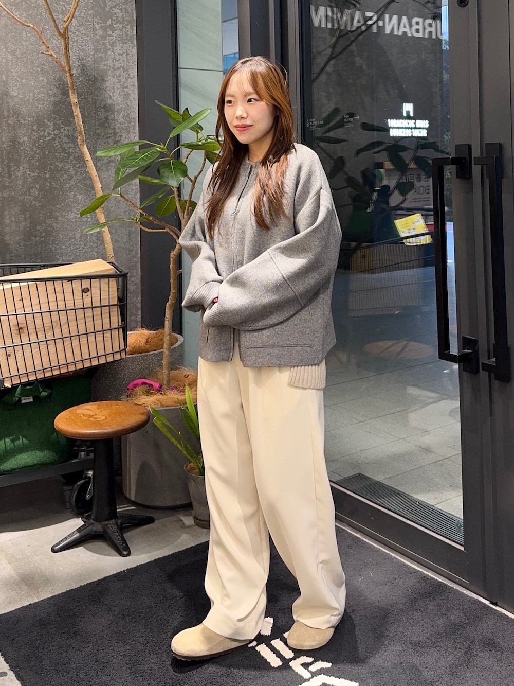 グレー系のブルゾン、ベージュ系のニット/セーター、ホワイト系のその他パンツを着用したレディースの秋コーディネートの2枚目の写真