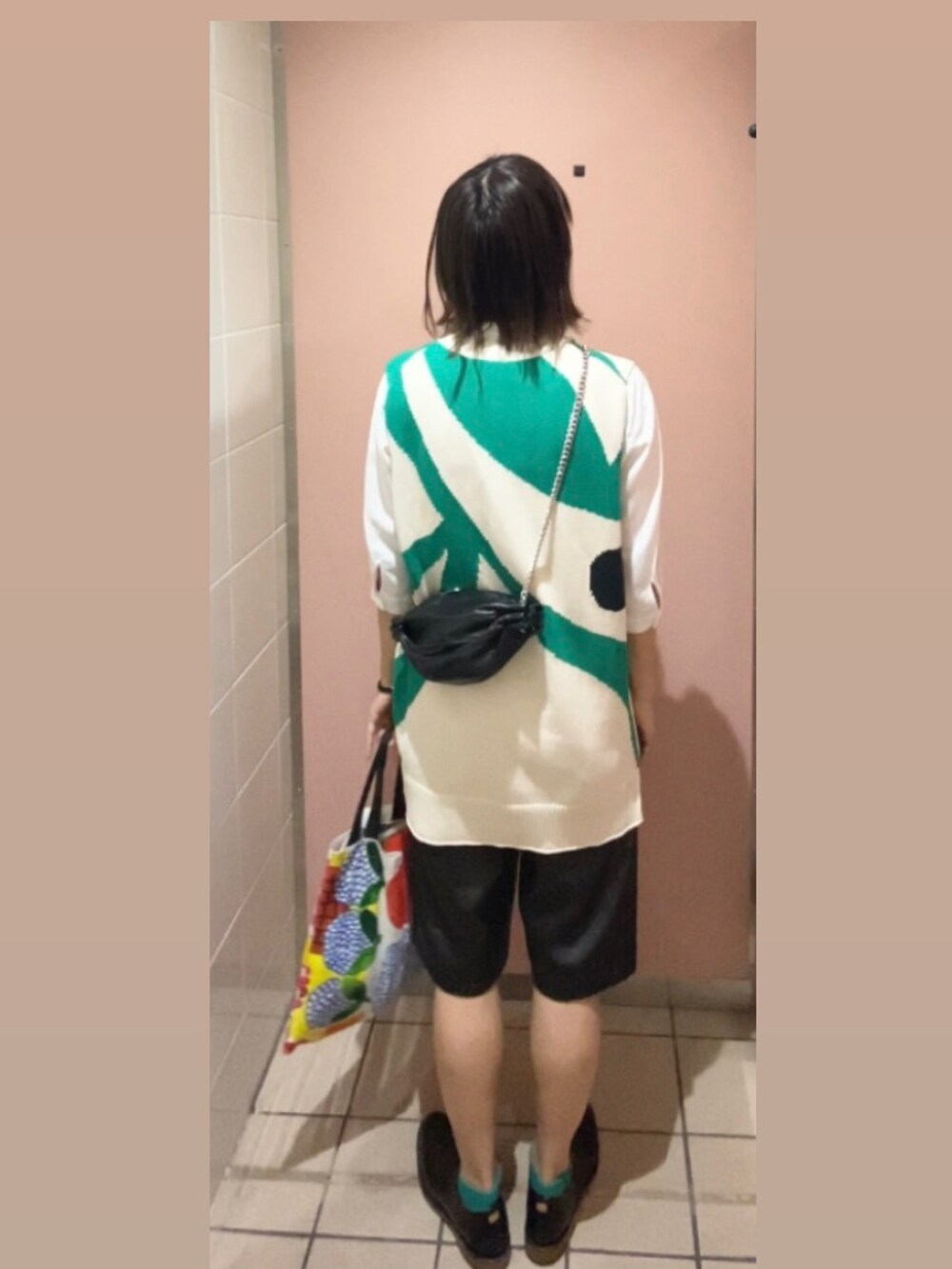 ブラック系のドレスシューズ、ホワイト系のトートバッグ、グリーン系のニット/セーターを着用したレディースの春コーディネートの3枚目の写真