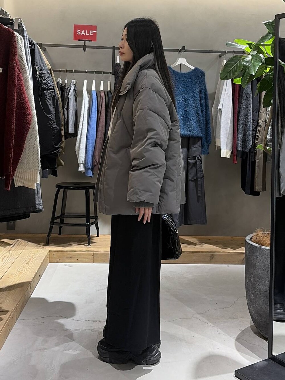 ブラック系のブーツ、グレー系のブルゾン、ブルー系のニット/セーターを着用したレディースの冬コーディネートの2枚目の写真