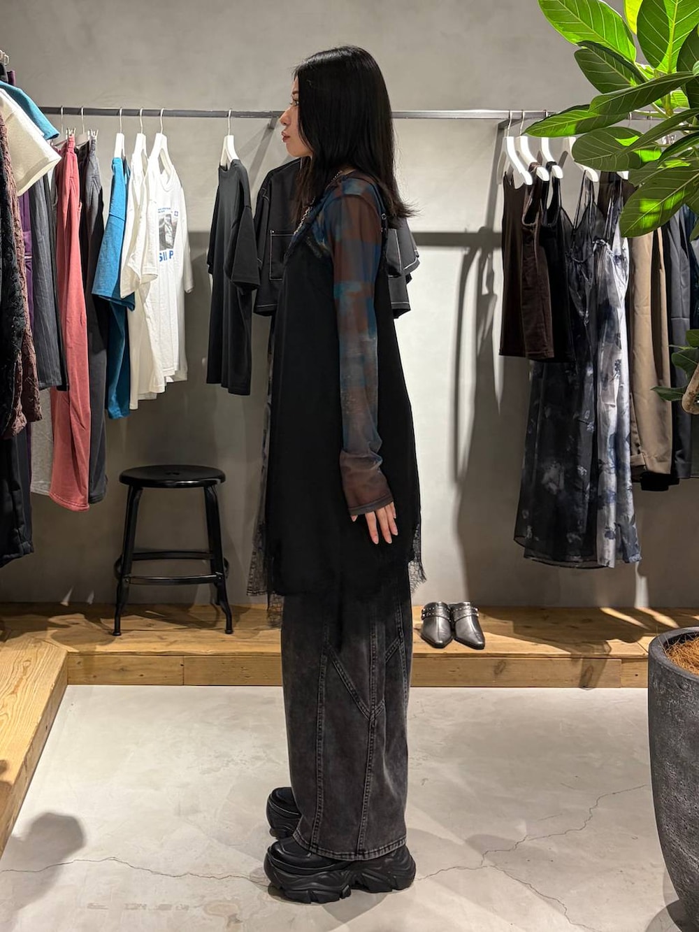 ブラック系のチュニック、ブラック系のスニーカー、ブラック系のデニムパンツを着用したレディースの夏コーディネートの2枚目の写真