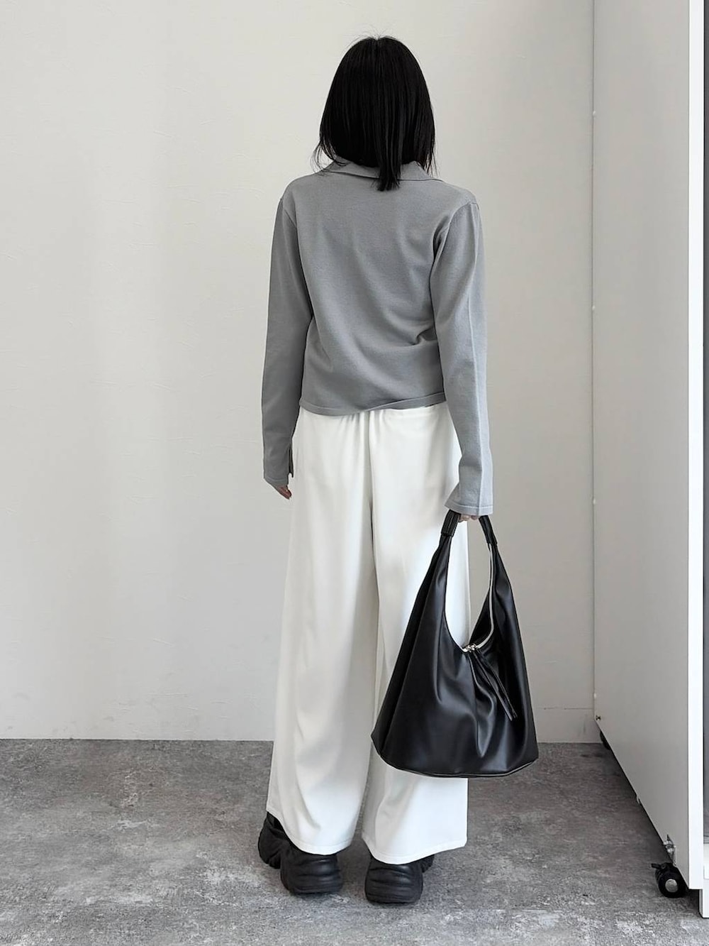 ブラック系のブーツ、ブラック系のトートバッグ、グレー系のカーディガン/ボレロを着用したレディースの冬コーディネートの3枚目の写真