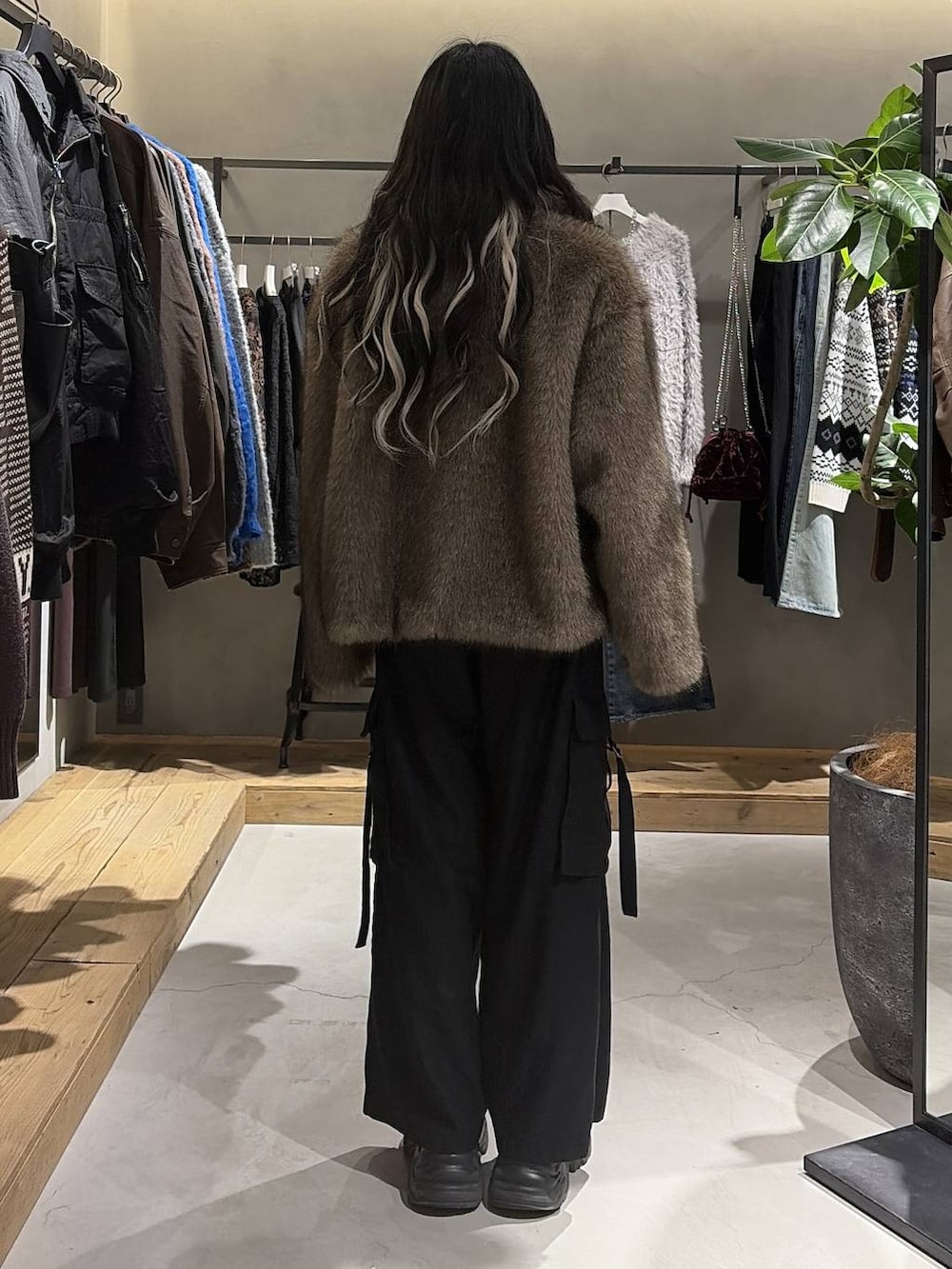 ブラック系のブーツ、ブラック系のスラックス、ブラウン系のブルゾンを着用したレディースの冬コーディネートの3枚目の写真