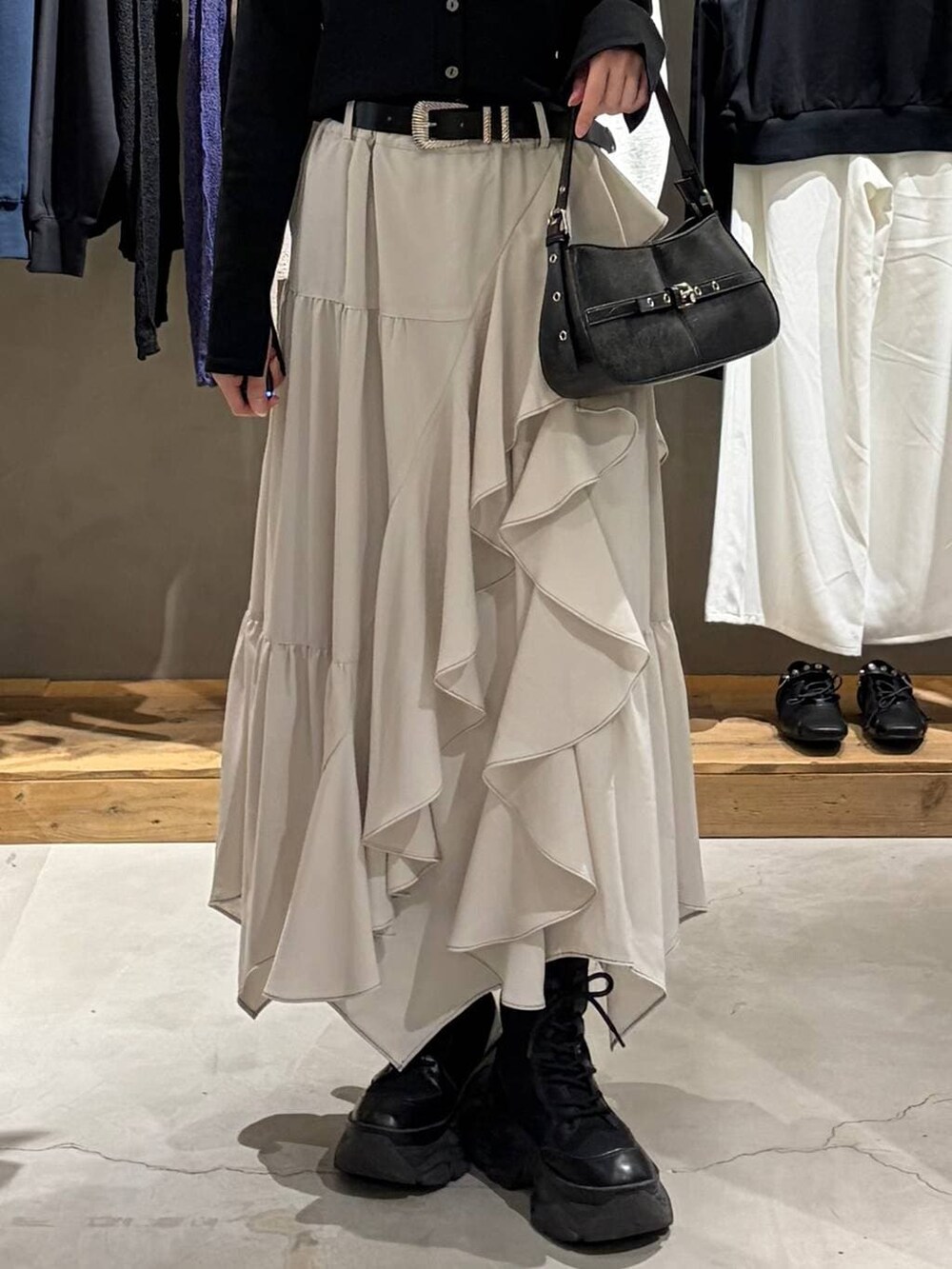 ベージュ系のスカート、ブラック系のハンドバッグ、ブラック系のカーディガン/ボレロを着用したレディースの春コーディネートの5枚目の写真