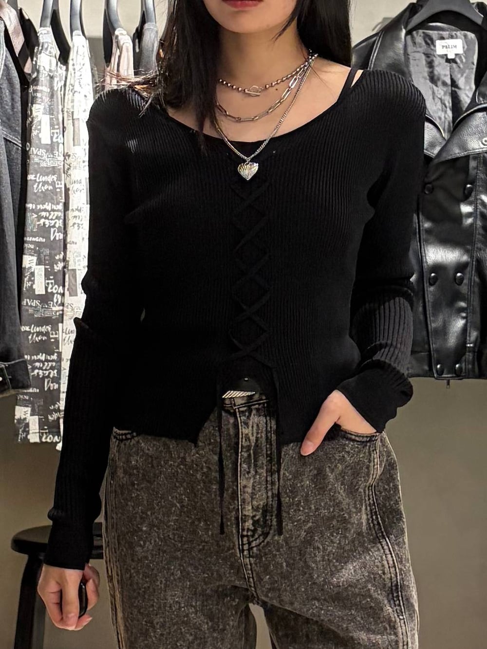 ブラック系のニット/セーター、ブラック系のデニムパンツ、シルバー系のネックレスを着用したレディースの秋コーディネートの4枚目の写真