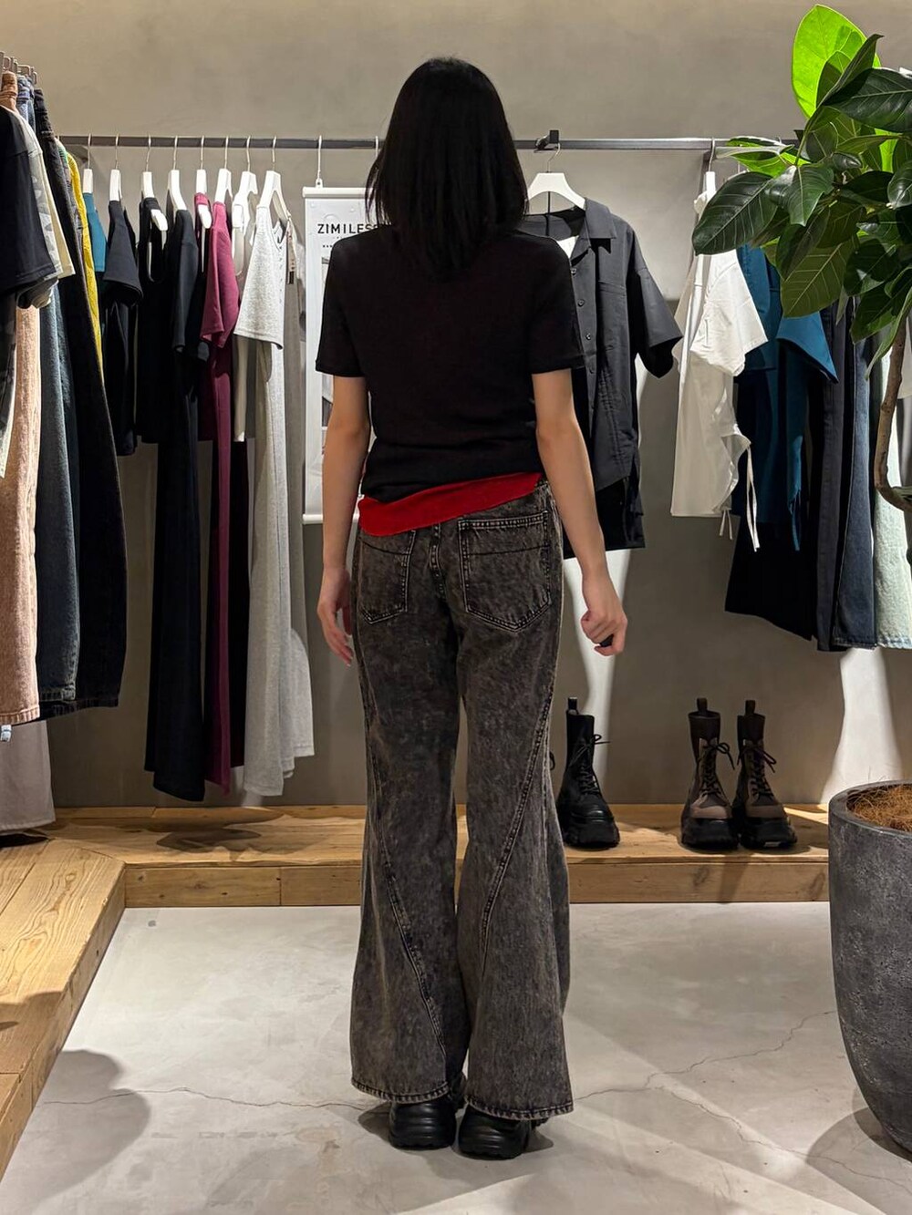 ブラック系のスニーカー、ブラック系のデニムパンツ、レッド系のTシャツ/カットソーを着用したレディースの夏コーディネートの3枚目の写真