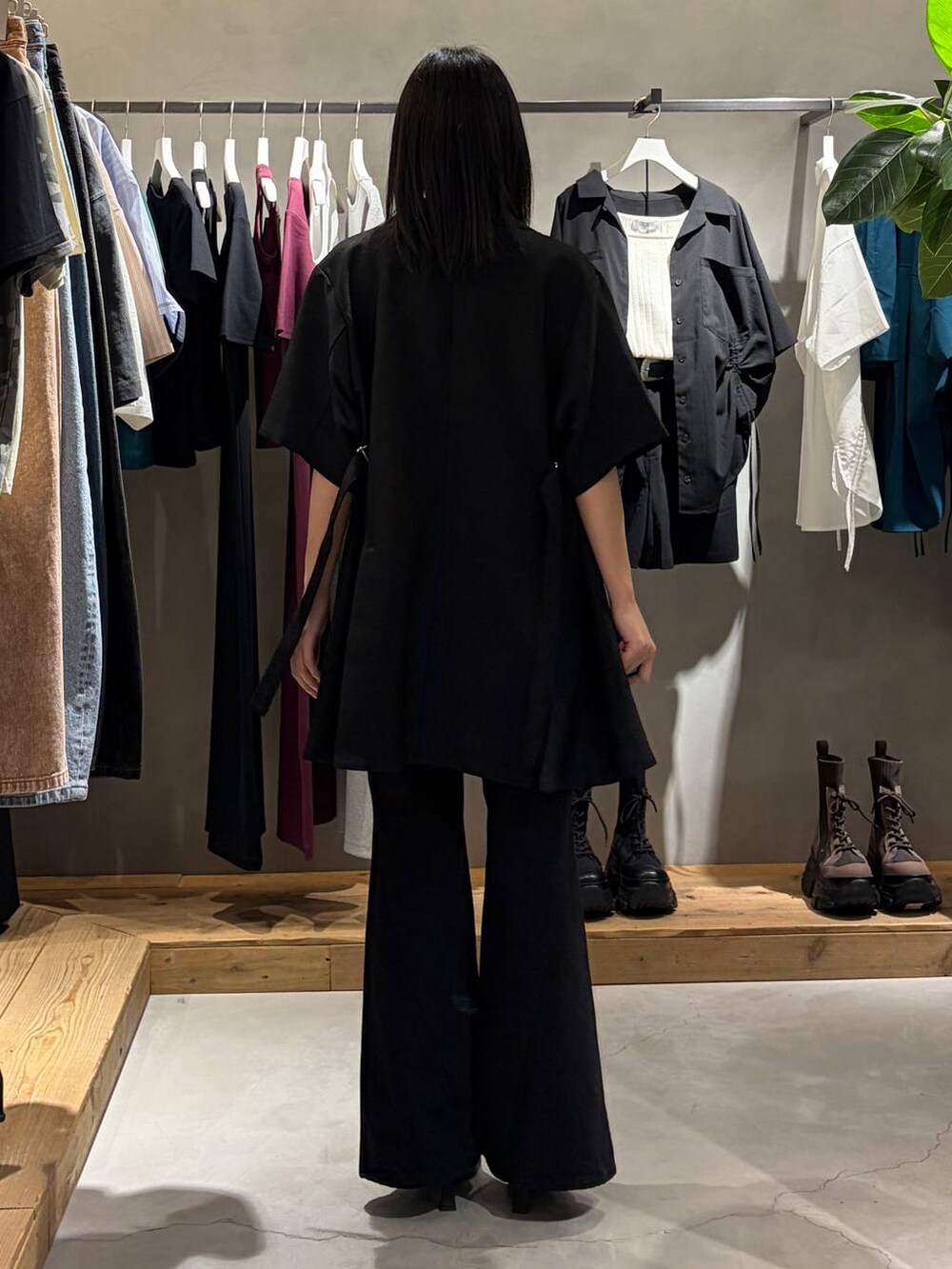 ブラック系のデニムパンツ、ブラック系のサンダル、ブラック系のテーラードジャケットを着用したレディースの春コーディネートの3枚目の写真