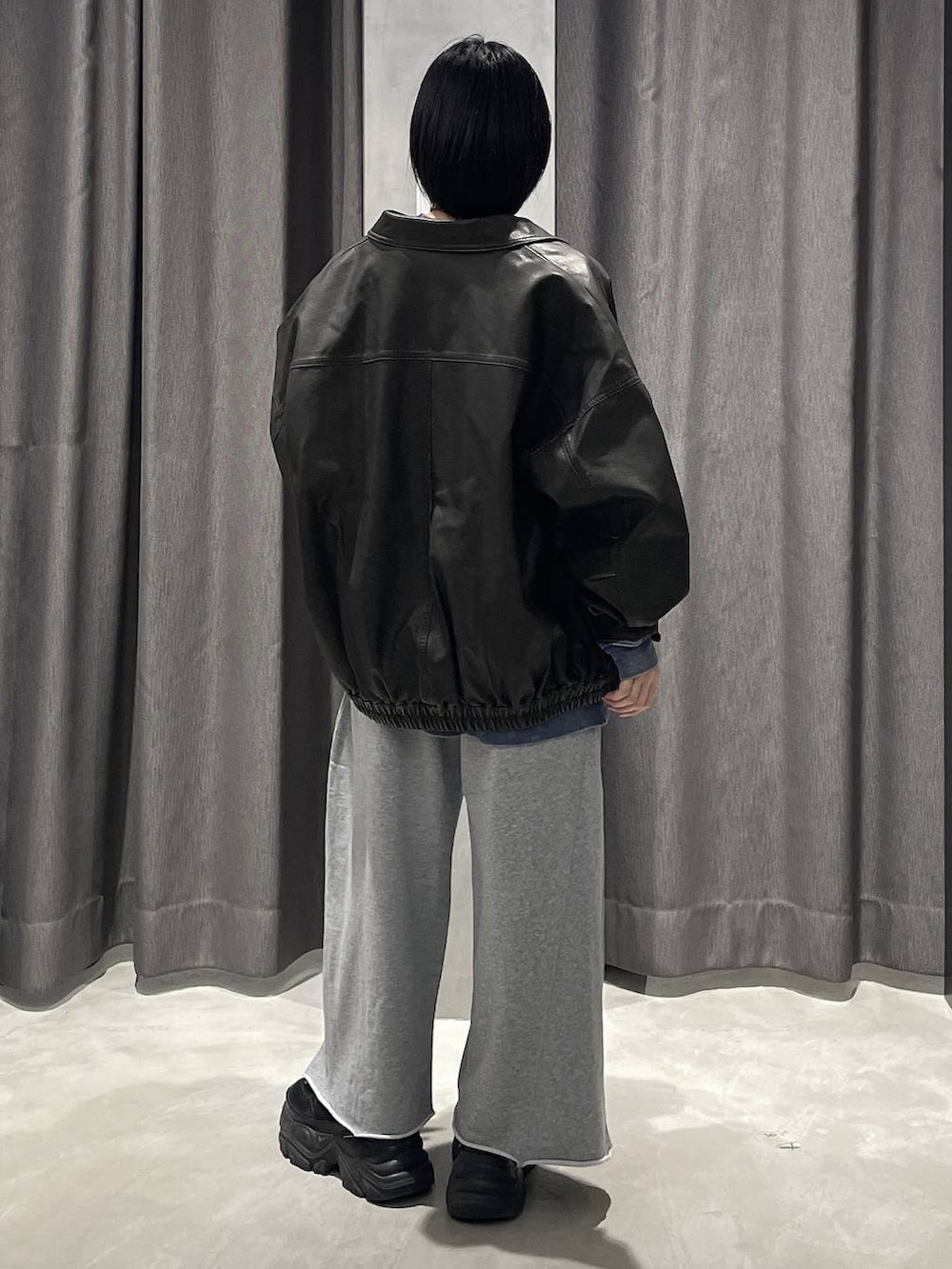 ブラック系のブーツ、グレー系のスウェットパンツ、ブラック系のブルゾンを着用したレディースの秋コーディネートの3枚目の写真