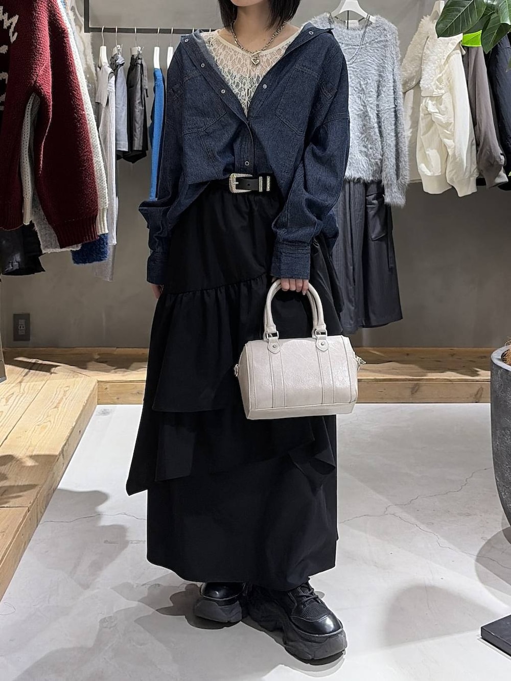 ホワイト系のブルゾン、ホワイト系のTシャツ/カットソー、ブラック系のスカートを着用したレディースの冬コーディネートの6枚目の写真