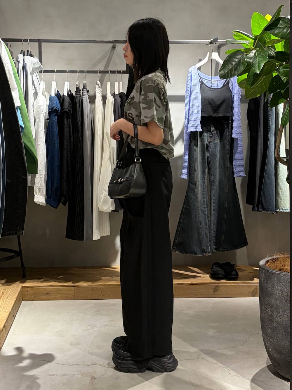 ブラック系のブーツ、ブラック系のハンドバッグ、その他のTシャツ/カットソーを着用したレディースの春コーディネートの2枚目の写真