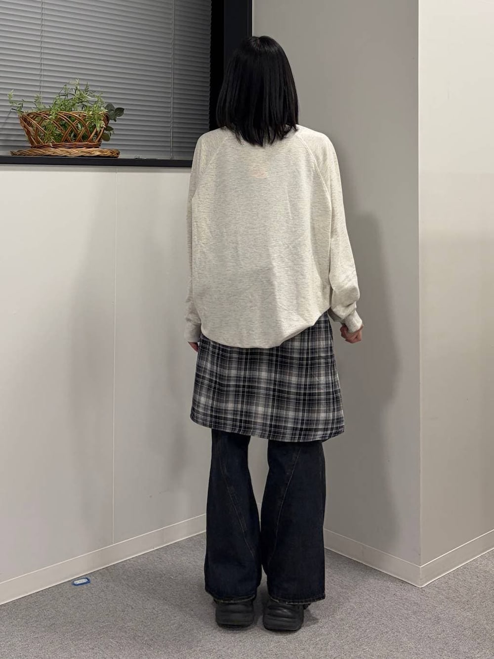 ブラック系のブーツ、ブルー系のデニムパンツ、ベージュ系のTシャツ/カットソーを着用したレディースの春コーディネートの3枚目の写真