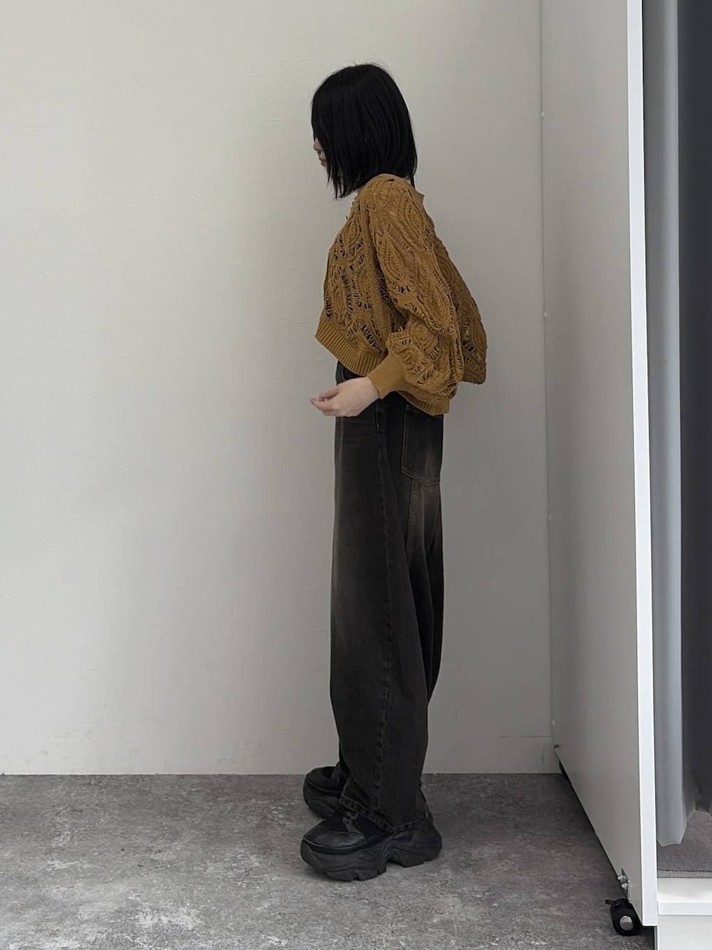 イエロー系のカーディガン/ボレロ、ブラック系のデニムパンツ、シルバー系のネックレスを着用したレディースの冬コーディネートの2枚目の写真