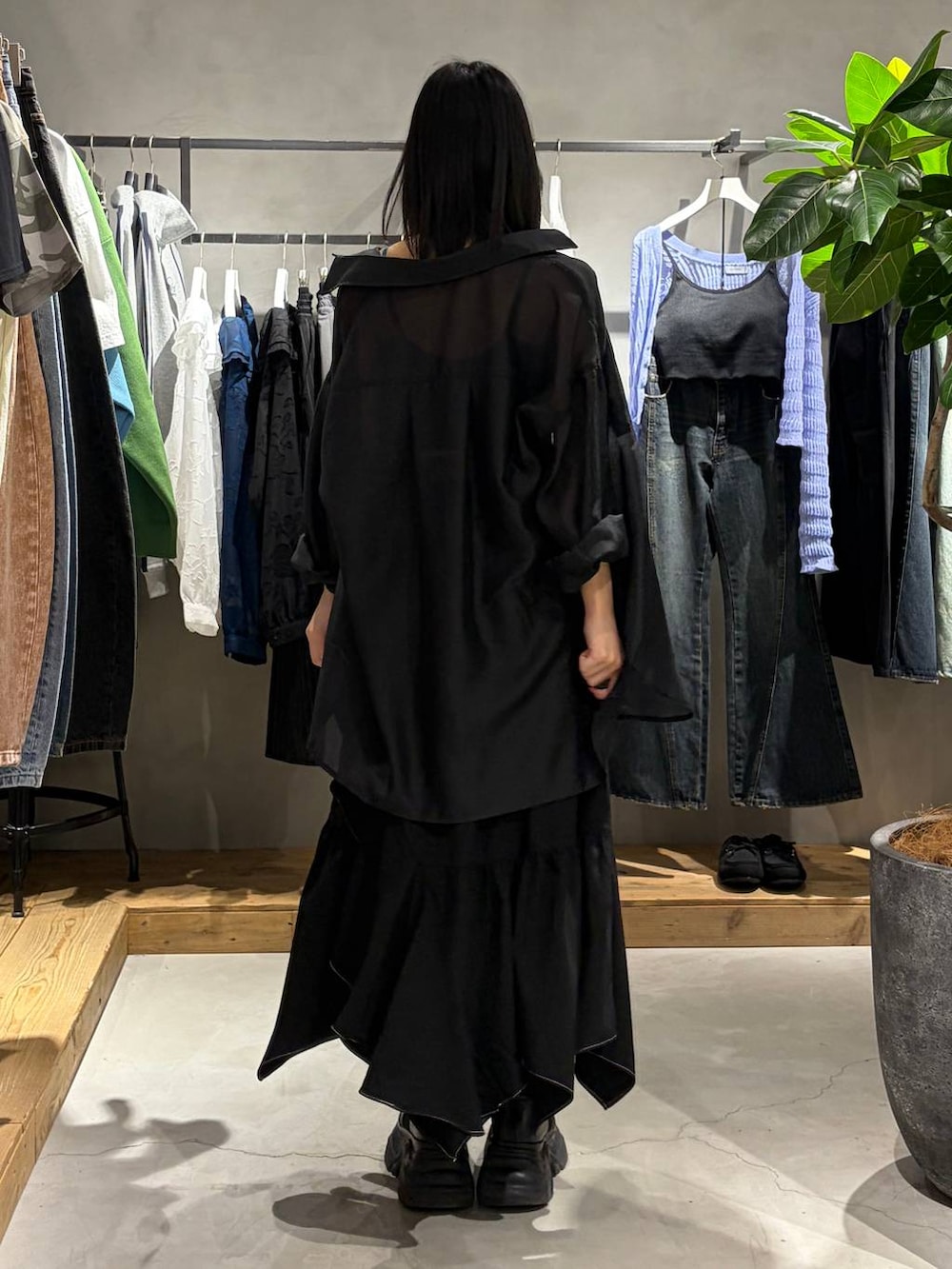 ブラック系のブーツ、グリーン系のキャミソール、ブラック系のスカートを着用したレディースの春コーディネートの3枚目の写真