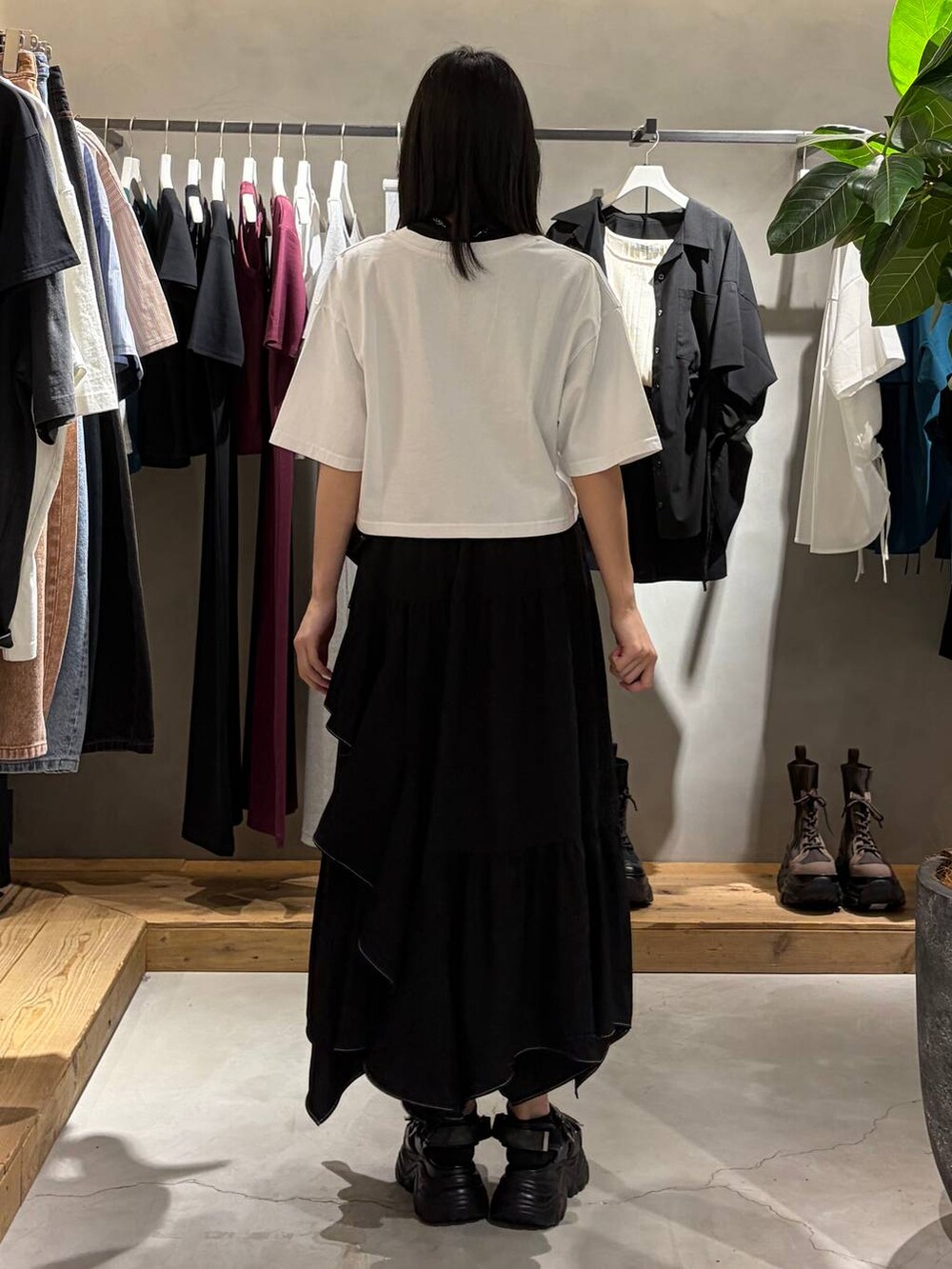ブラック系のスカート、ブラック系のサンダル、ホワイト系のTシャツ/カットソーを着用したレディースの春コーディネートの3枚目の写真