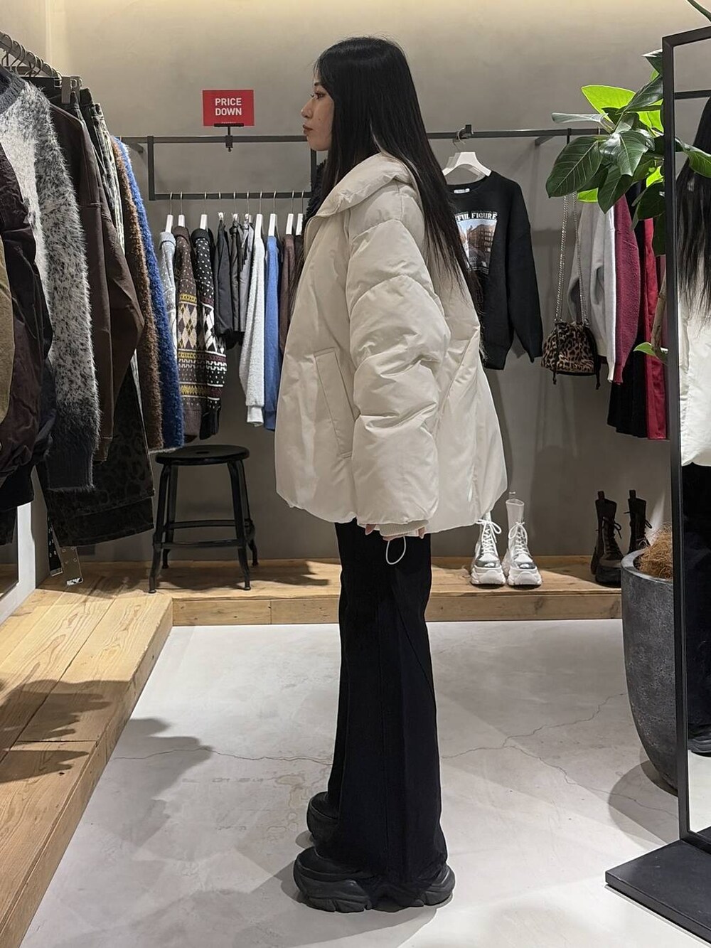 ブラック系のブーツ、ブラック系のデニムパンツ、ホワイト系のブルゾンを着用したレディースの冬コーディネートの2枚目の写真