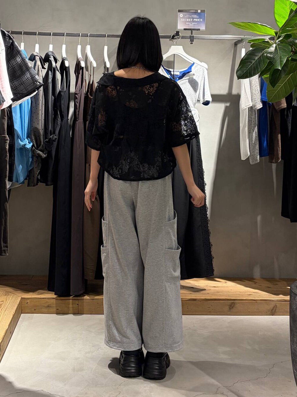 ブラック系のスニーカー、ブラック系のシャツ/ブラウス、グレー系のスウェットパンツを着用したレディースの夏コーディネートの3枚目の写真