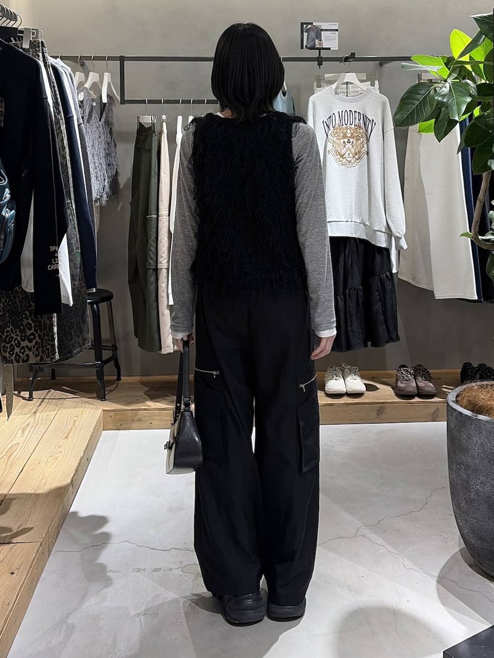 ブラック系のブーツ、ブラック系のハンドバッグ、ブラック系のスラックスを着用したレディースの冬コーディネートの3枚目の写真